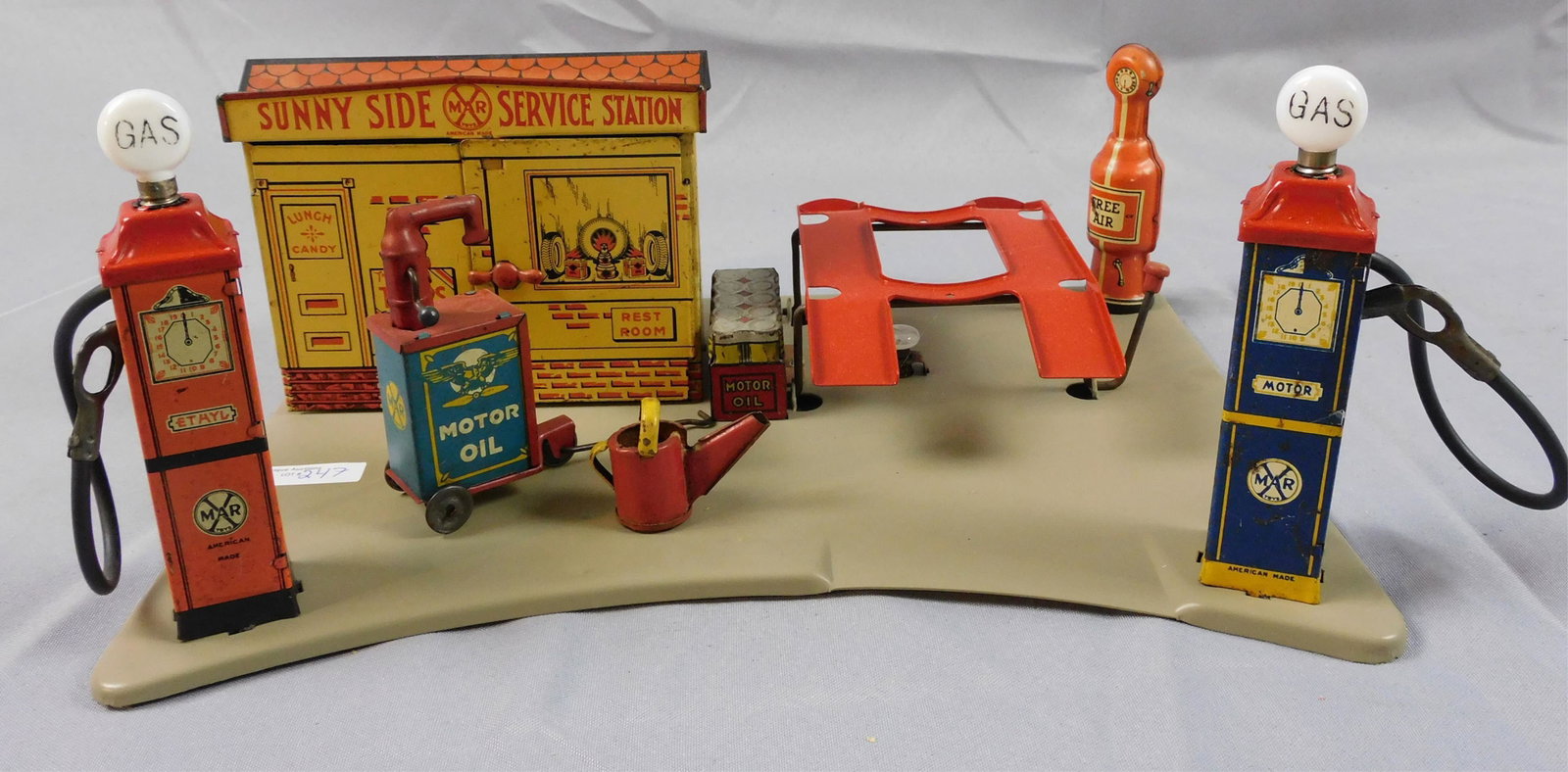 Marx Sunnyside Service Station, ca. 1930s. Tin: litho, includes a water can and oil pump station. Gas pumps have gas globes, tubes, and nozzles. 6" high, 13 1/2" wide, 10" deep.