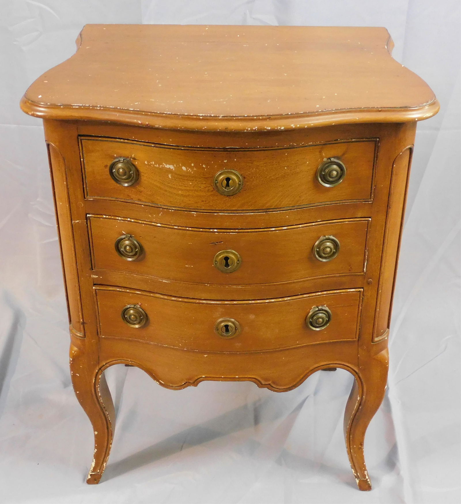 Mahogany 3 drawer commode with a painted faux: wood finish. 18th c. Original cotter pin brasses, 3 drawers with shaped panel sides. European pine secondary wood. Right rear leg shows old repair. 31 1/2" high, 24" wide, 16 1/2" deep.