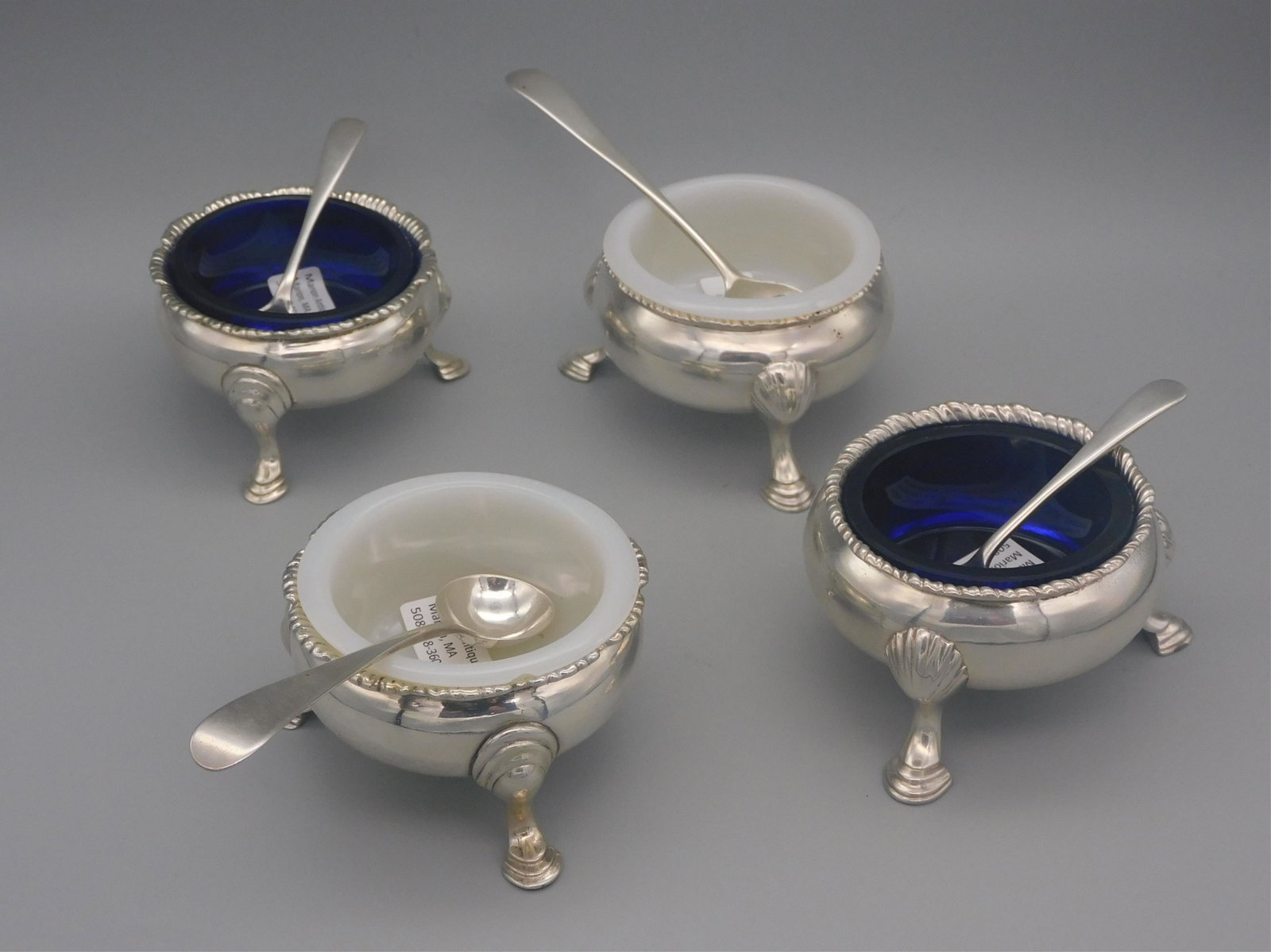 (4) English sterling silver open salt dishes. One: pair is George III, London, 1763, maker DM, comes with two Georgian salt spoons. Along with a pair of Georgian salt dishes, cobalt glass liners, comes with two English sterling salt spoons.