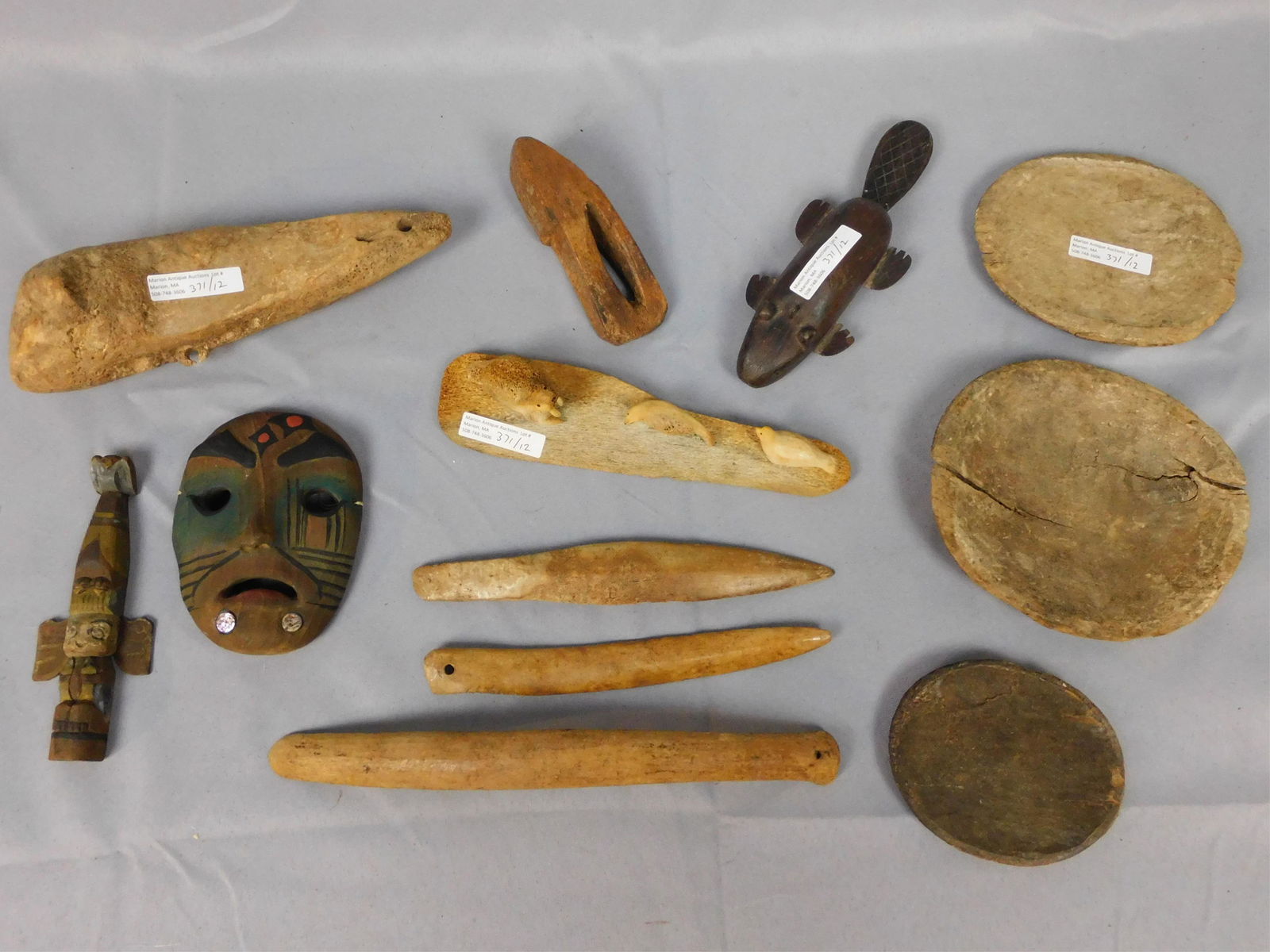 (12) Inuit wood and bone items, tools, etc. 19th: and early 20th c. To include: polychrome totem (6"), high polychrome carved mask with abalone (5"), carved bone sculpture of seals and walrus (8 1/2" long), tin and wood baby beaver lure (7 1/2" long)