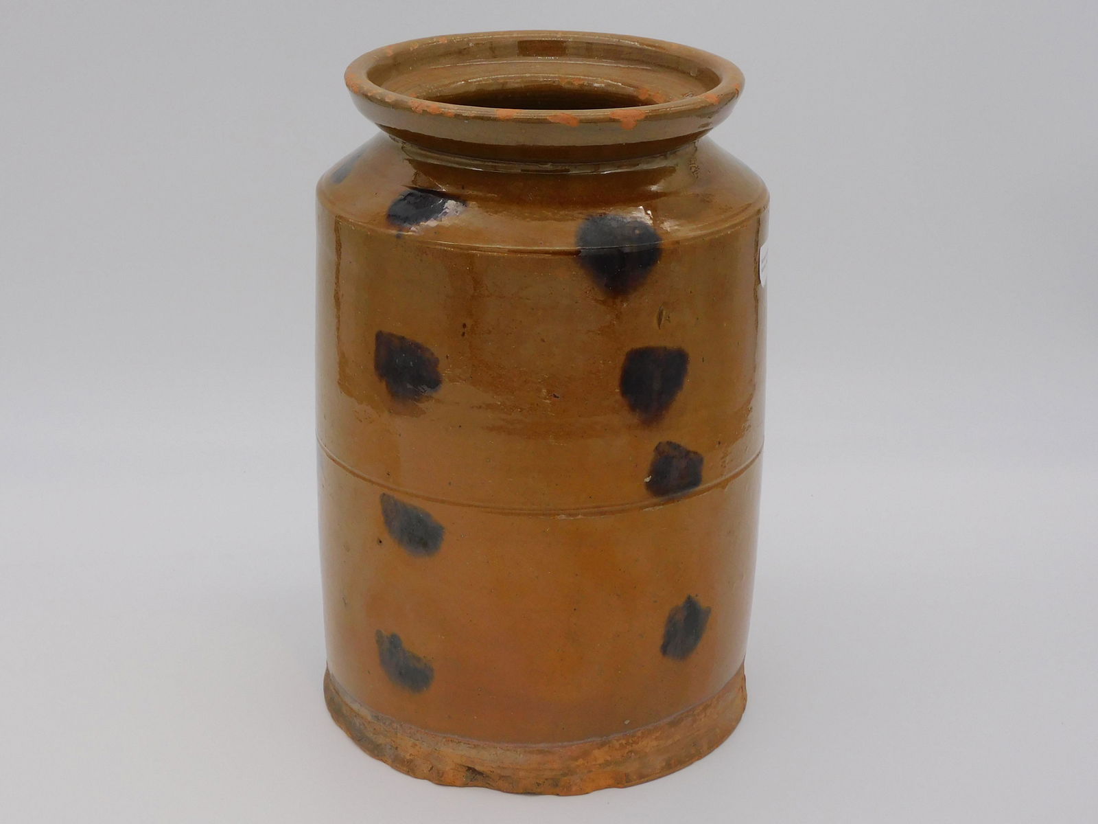 A redware storage jar with dark spotted design.: 19th c. 10 1/2" high, 7" diameter. Possibly Maine origin. Shows some glaze flaking to rim, overall good condition.