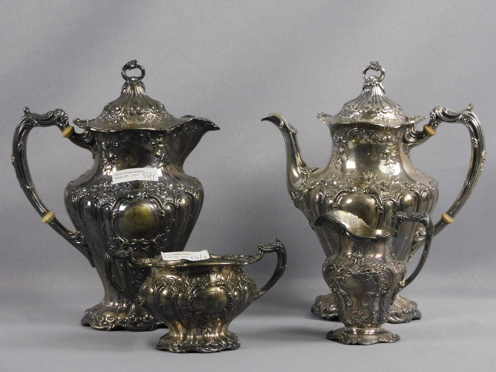 Ornate Gorham 4-piece tea set, to include: tea: pot, 10" high, 9" wide, 5" diameter, with monogram and dent. Lidded hot water kettle 10 1/4" high, 8" wide, 5" diameter, with monogram. Creamer 4 1/2" high, 4 1/4" wide, 3" diameter, with monogram. Op
