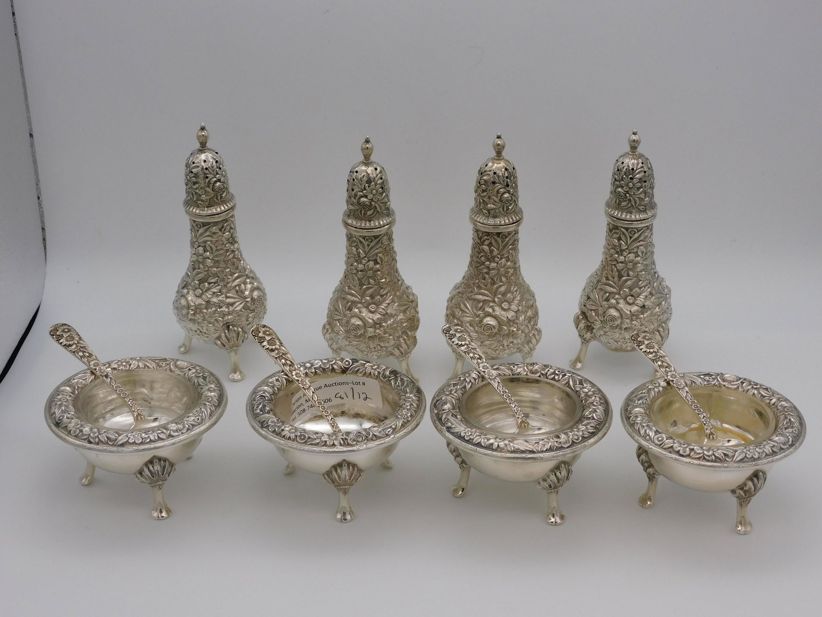 (12) silver pieces: 4 pairs of Kirk repousse: sterling silver pepper shakers, 4 1/2" high. Open salts with clear glass liners, 1 1/2" high, 2 3/4" diameter. 4 salt spoons, 3" long. 18.89 total ozt.