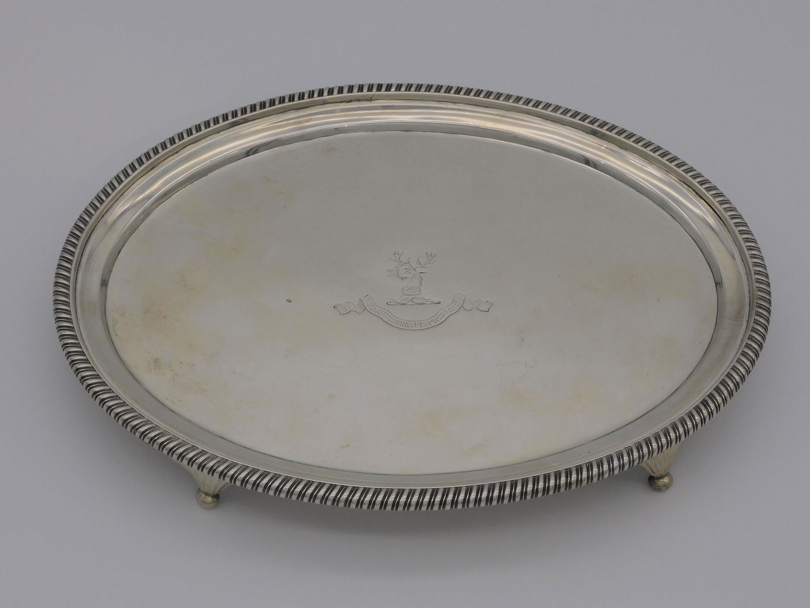 English silver footed tray, with engraved family: crest, early 19th c. possibly Hargreaves, and banner which reads "Fortitudine et Prudentia" (courage and prudence). London, 1806. Possibly by William Bennett. 1 1/4" high, 10" wide, 7 1/2" deep. 15.63