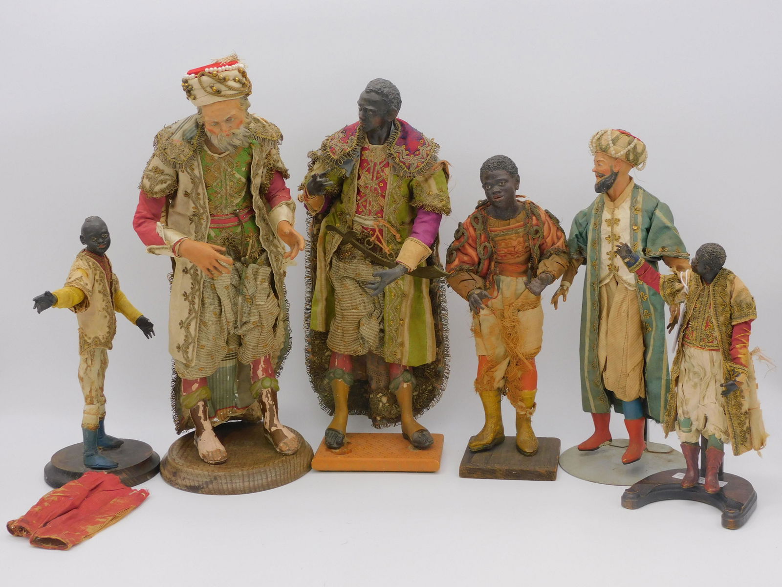 (8) Italian Neapolitan presepio creche figures,: late 18th and 19th centuries. The three kings and 3 attendants. To include: one is 14" high on a wooden stand, wearing a small dagger, elaborate silk brocade and metal lame clothing, metal trim, glass