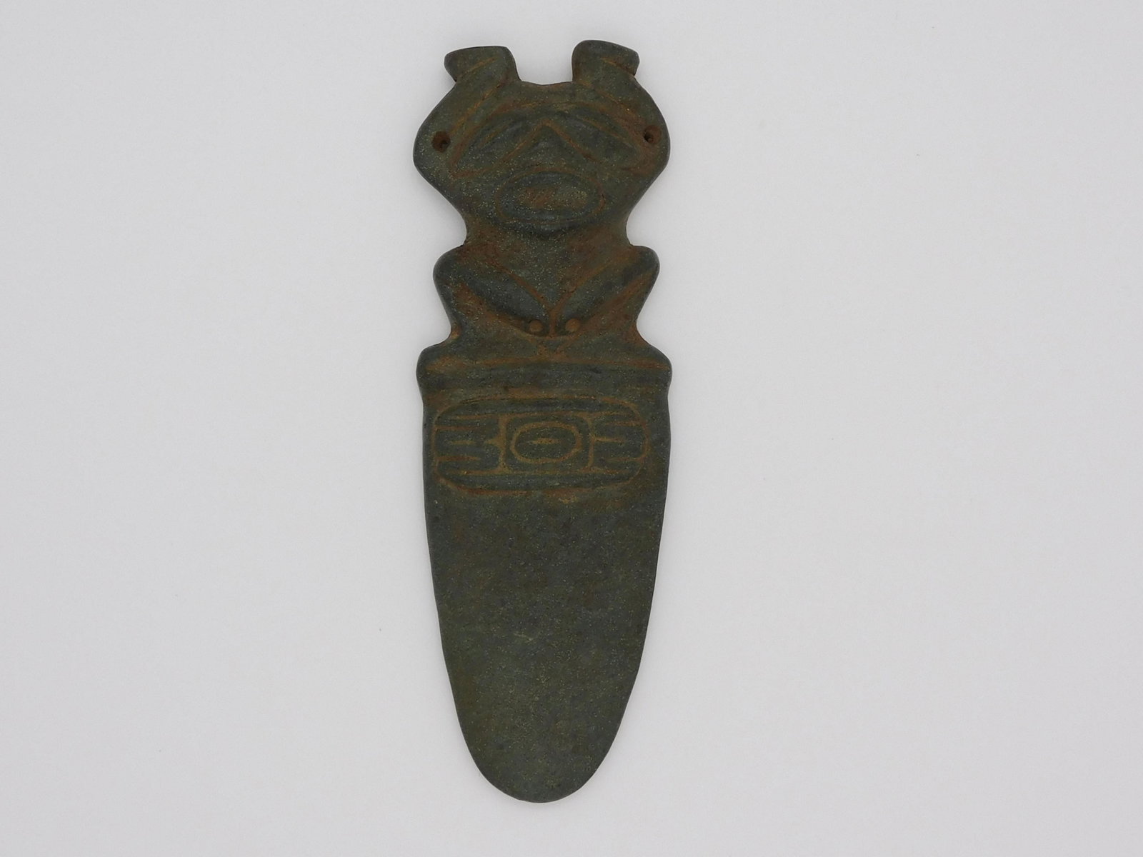 Taino, zoomorphic short purging spatula. Closed: eyes denote drug induced transcendence. Suspension holes at elbows suggest this was worn during ritual events probably to induce vomiting prior to taking cohoba. A symbolic panel is relief carved on t