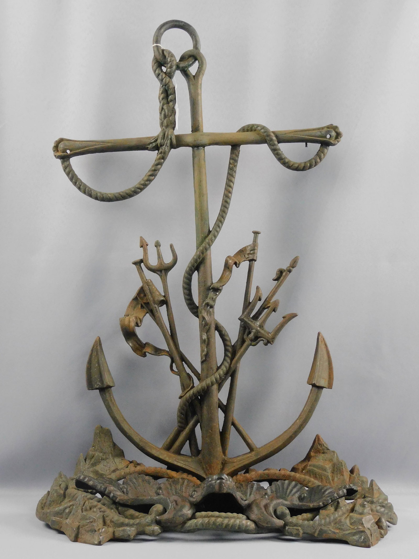 Nautical cast iron umbrella stand, 19th c.: Depicting anchor, Neptune's tridents, shell form removable drip pan. Finish shows some wear and oxidation. One trident tip is broken. 30" high, 20" wide, 10" deep. Provenance: Mary Jean McLaughlin Col