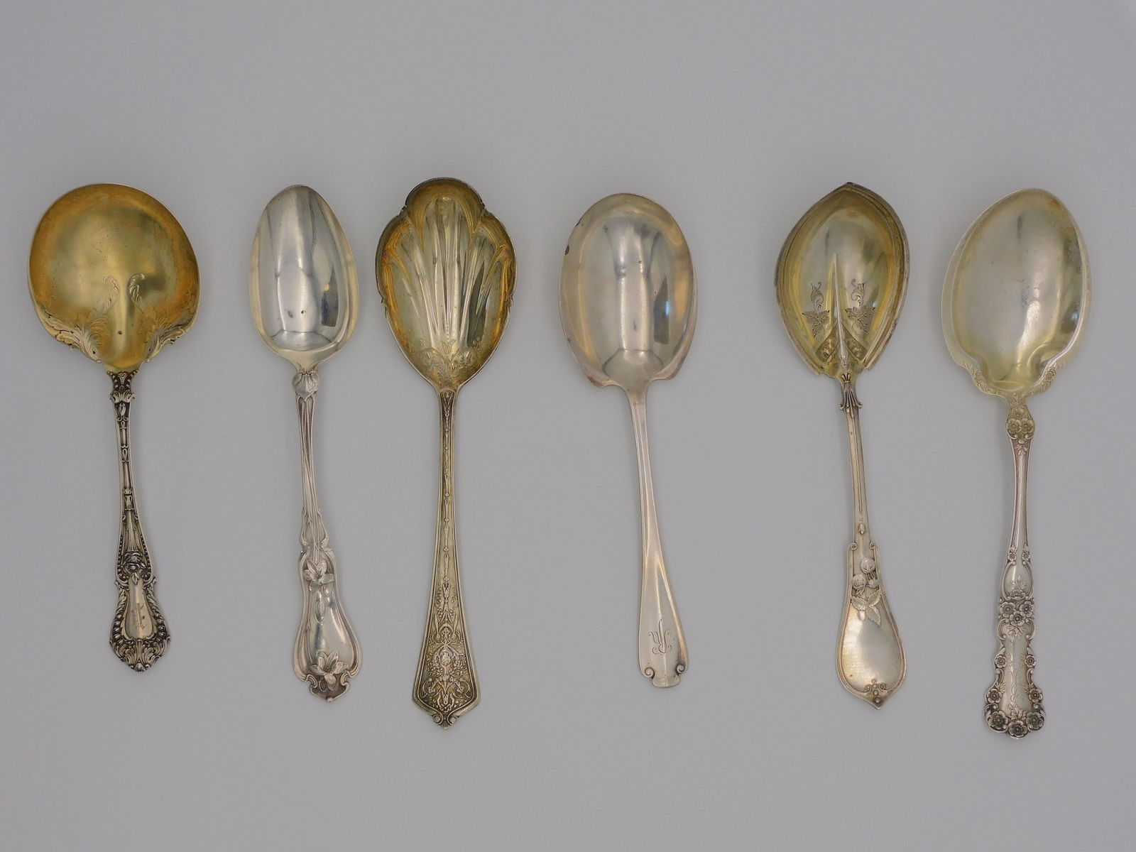 (6) sterling silver serving spoons. To include:: A. Stowell & Co with gold wash bowl, strawberry design, monogrammed, 8 1/4" long. Tiffany & Co. 7 3/4" long, Flemish pattern, monogrammed. Gorham with gold wash bowl Lady Washington pattern, 8 1/2" lo