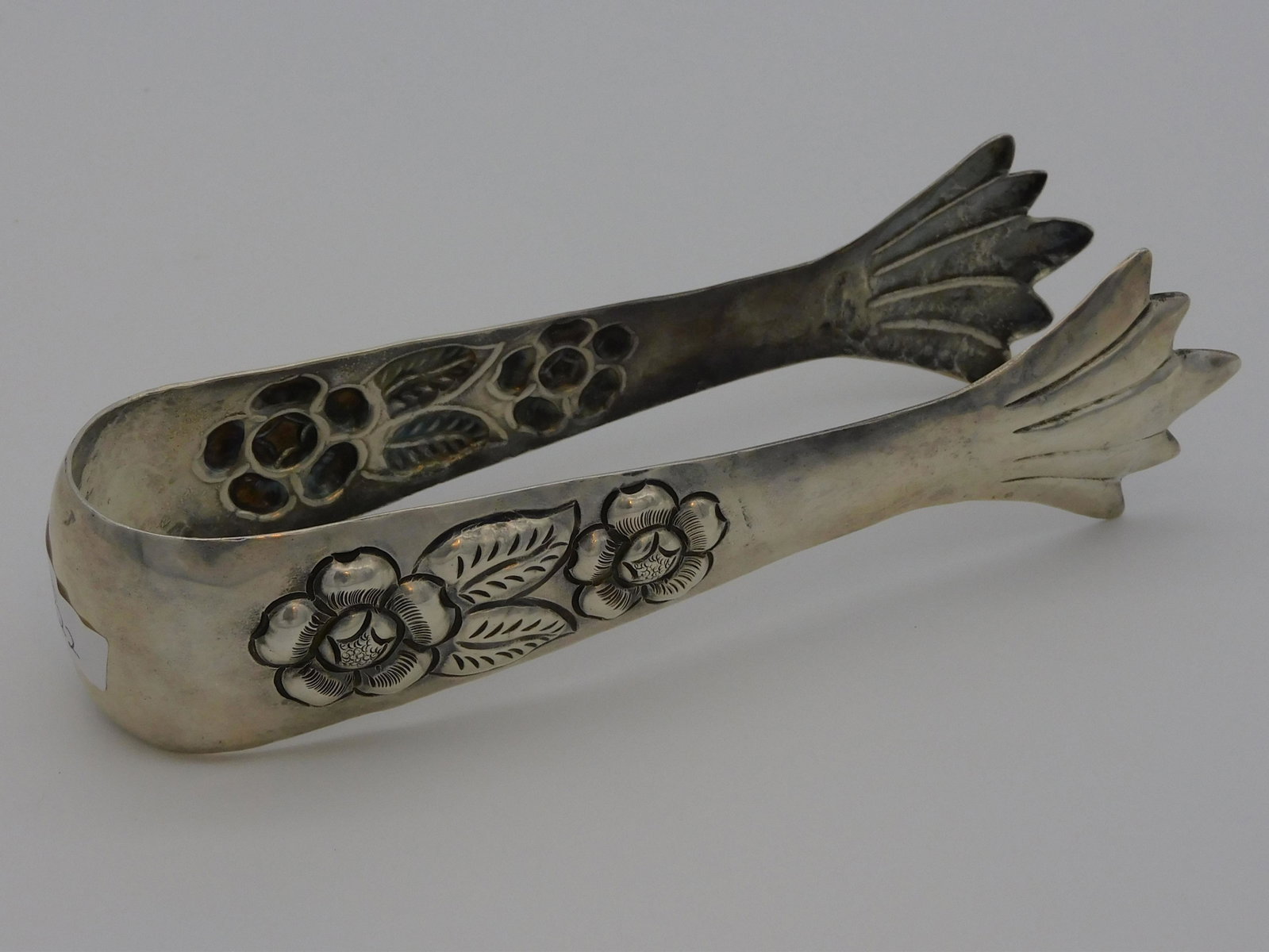 Metropoli Mexican sterling silver tongs, with: embossed floral designs. Marked Metropoli 925 Sterling inside. 7 3/4" long. 4.06 ozt.