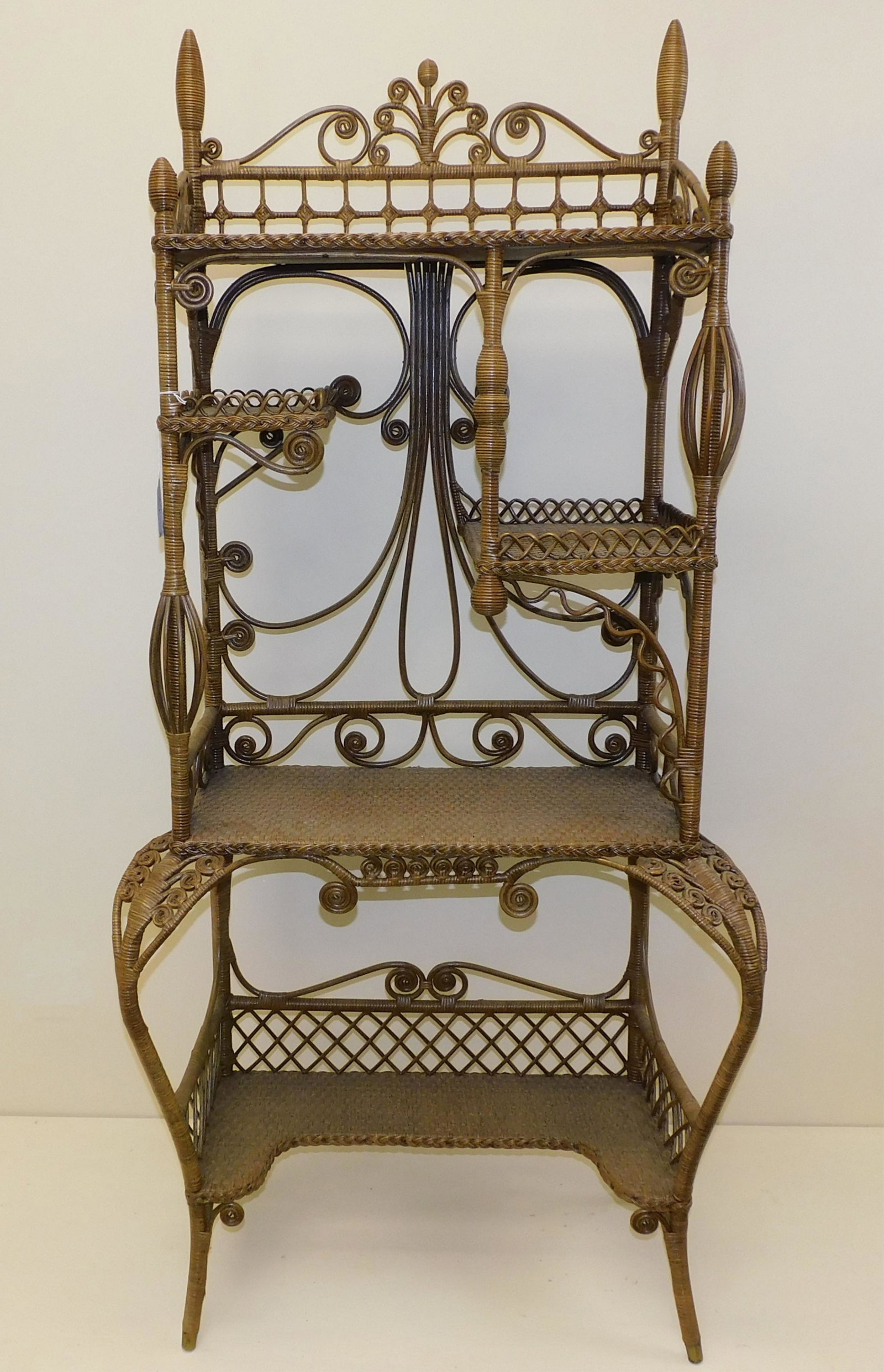 Heywood Brothers Wakefield Company fancy cabinet: / etagere, 1898. Original natural finish. The piece features a natural finish multi-tiered curlicue and birdcage design. Brass feet. Faded old paper makers label on underside of the shelf. The piece i