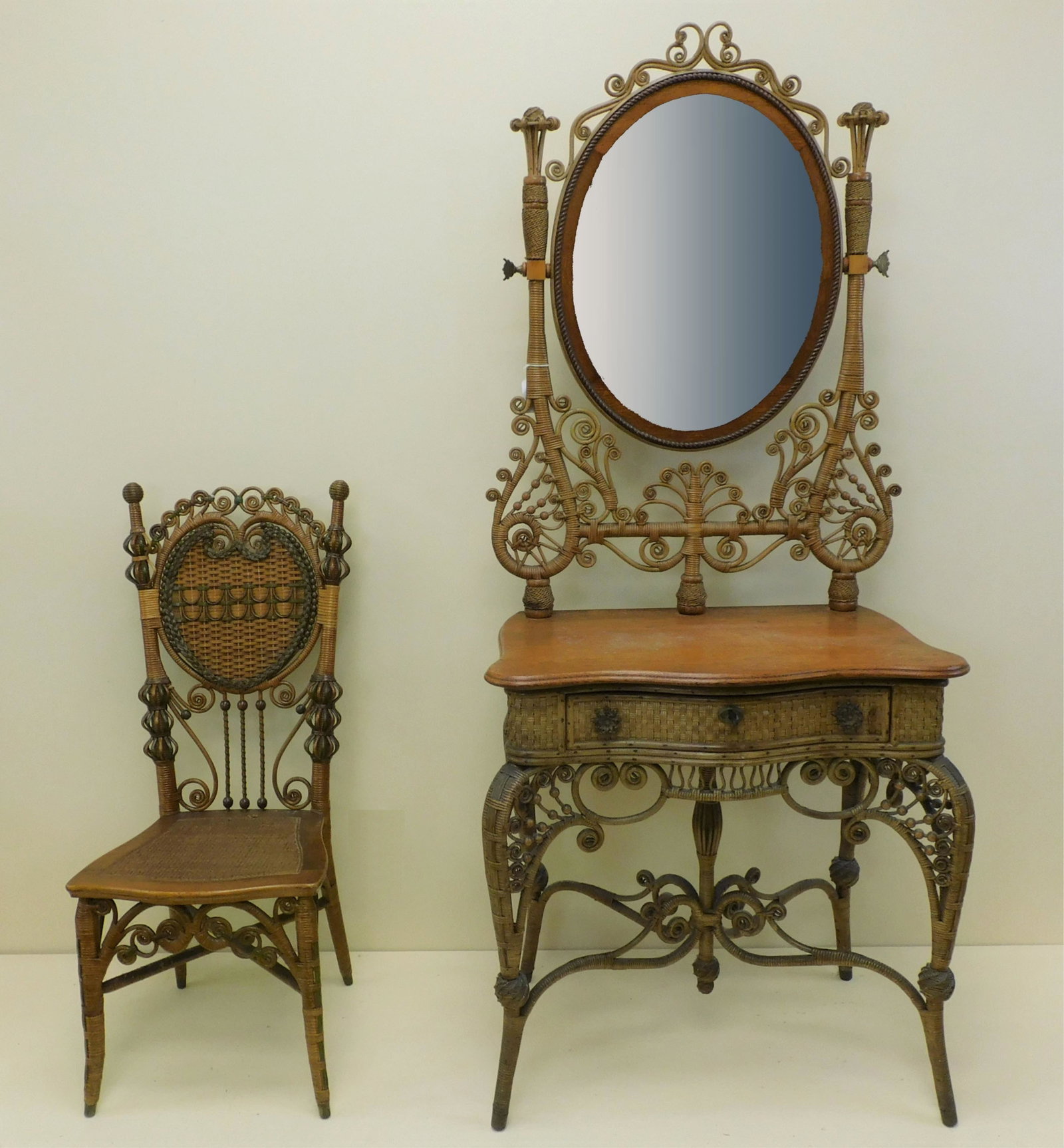 Heywood Brothers and Wakefield Company wicker: mirrored dressing stand/vanity with lady's reception chair, 1898. Vanity table consists of an oval oak beveled mirror, curlicued trim, ebullient harp, golden oak shaped top. A single drawer with key a