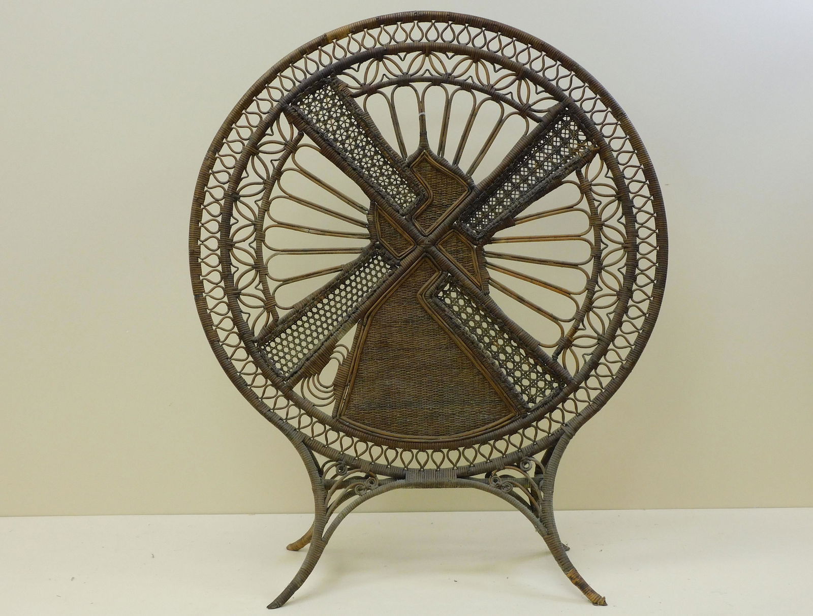 Very rare Victorian fire screen, ca. 1870.: Possibly by the Wakefield Rattan Co. It has a round bentwood frame. It features a windmill motif, interior natural star caned and closed cane panels. Supported by four curved saber legs. 42" high, 35"