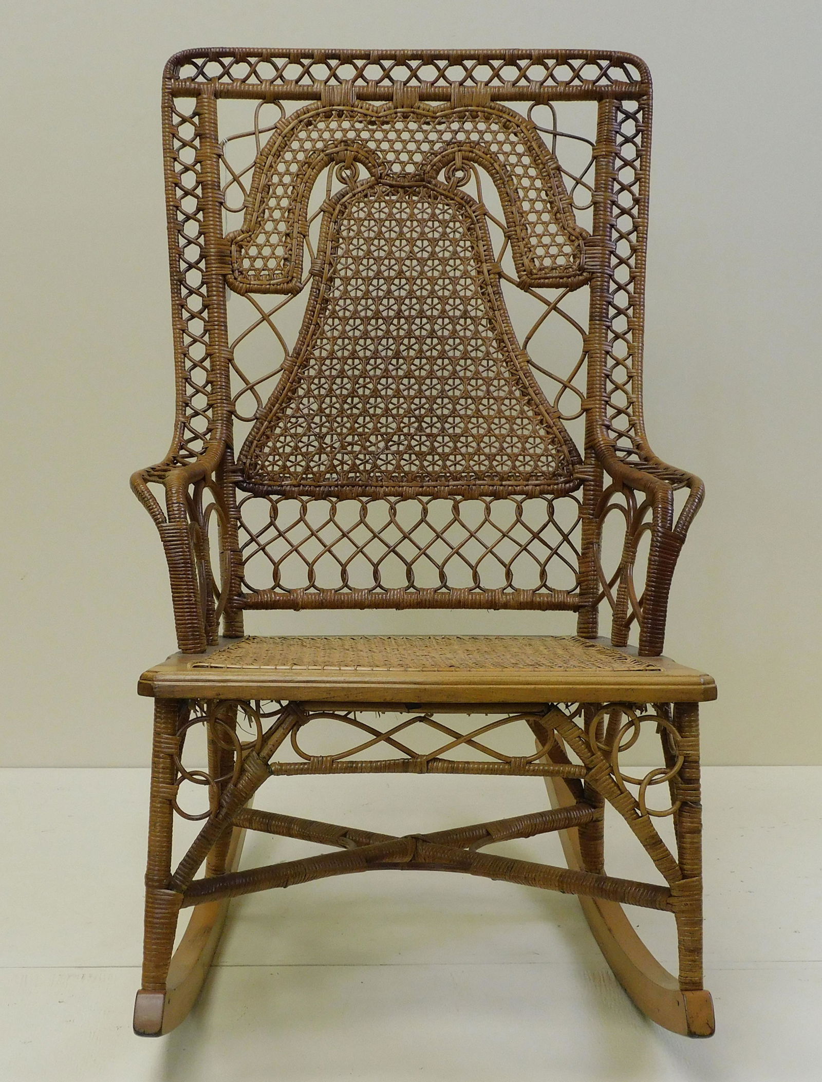 Victorian theme back rocking chair, ca. 1876.: Star caned back depicting the Liberty Bell motif, probably by the Wakefield Rattan Co. Maple frame and rattan weaving. Possibly made for the Philadelphia Centennial Exhibition. 36" high, 22" wide, 29"