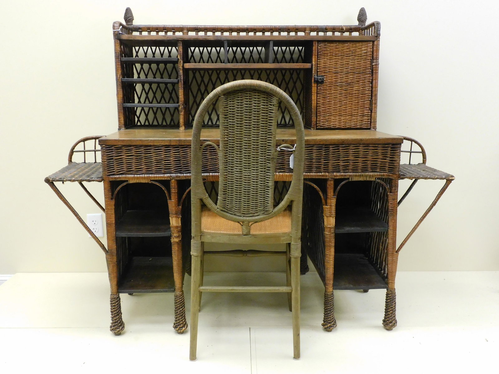 Arts and Crafts American wicker desk, oak and: willow. Ca. 1910. Features a gallery with single door and pigeonhole compartments. Two attached side shelves and four lower shelves. Cone feet. Original natural finish, probably Paines Furniture Compa