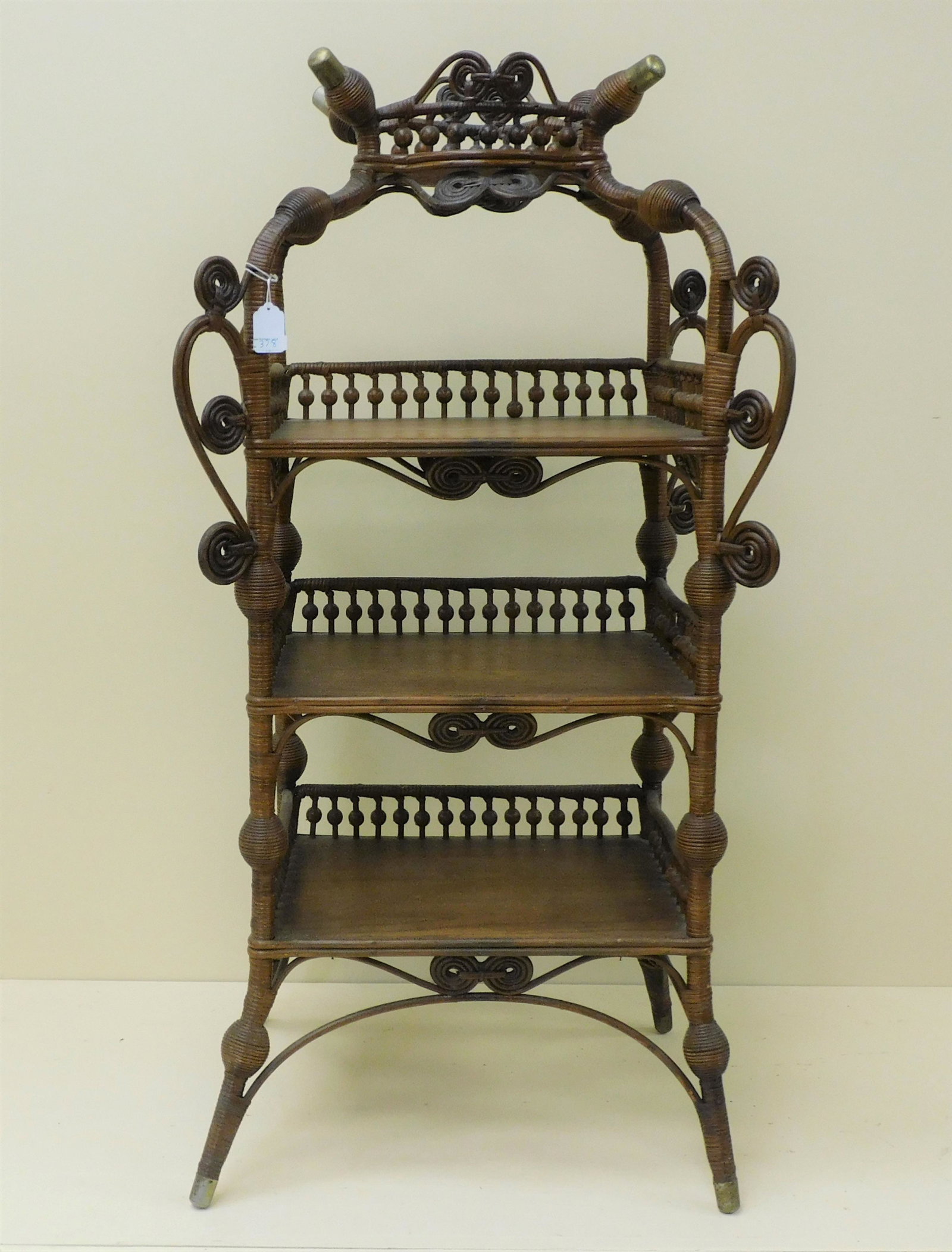 Victorian wicker etagere with oak frame and: shelves. Heywood Brothers Wakefield Co., ca. 1898. Four tiers with a beaded gallery. Original natural finish. 43 1/2" high, 21 1/2" wide, 13 1/2" deep. Excellent condition overall. Provenance: Mary Je