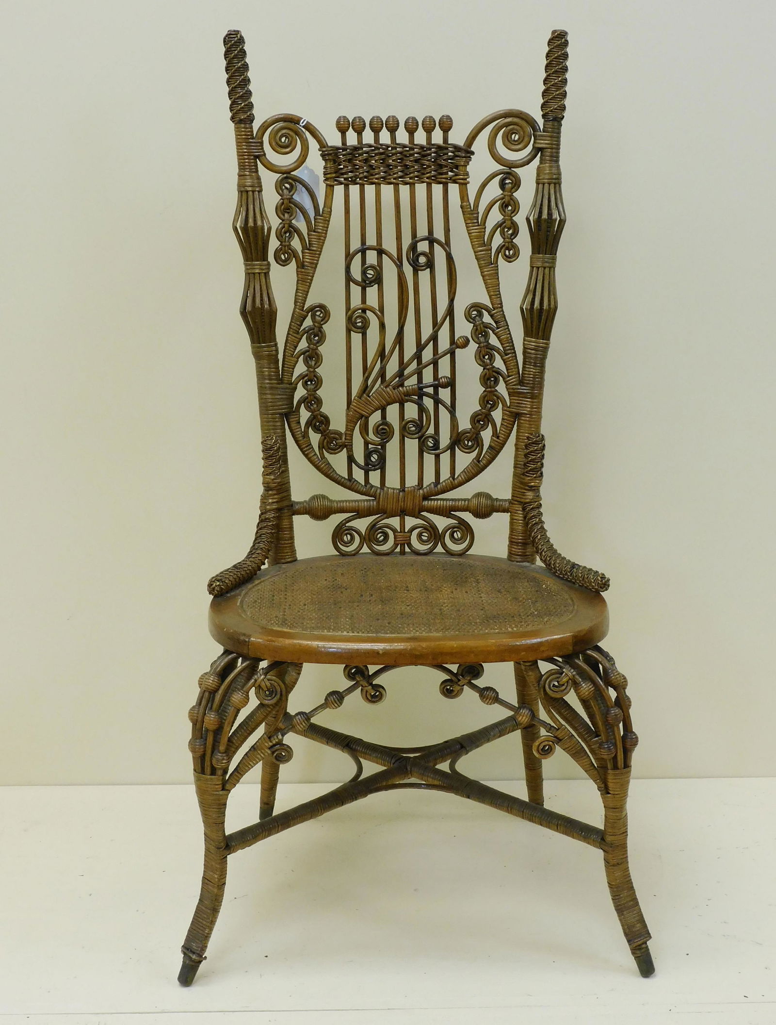 Victorian wicker side chair, ca. 1890, elaborate: lyre shaped back. Rattan with maple frame. Beaded birdcage design on front legs. Original natural finish, someone has applied a light coat of satin urethane over it. 42" high, 19" wide, 18" deep. Over