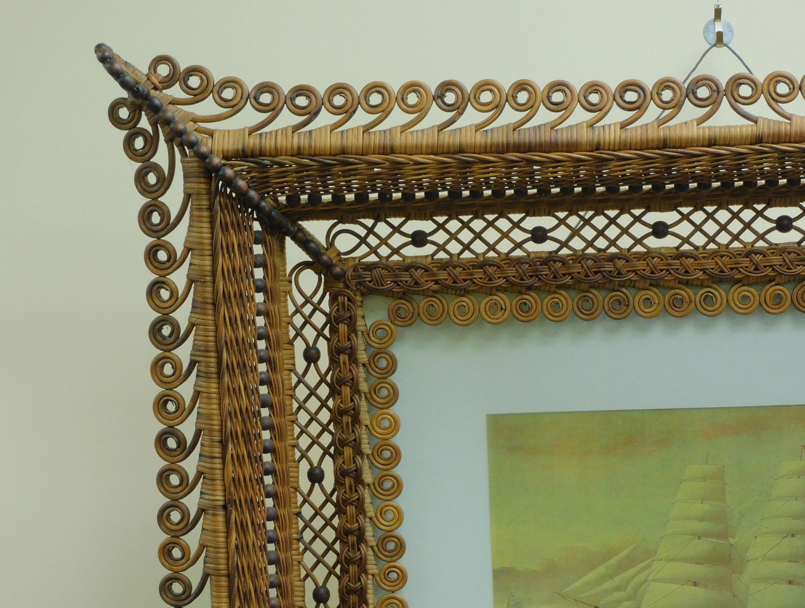 Rare Victorian wicker frame with elaborate: curlicue borders. Original natural finish. Containing a print of a 3-masted ship under sail. 36" x 39". 3" deep. Good original condition with four beads missing on one corner. Provenance: Mary Jean Mc