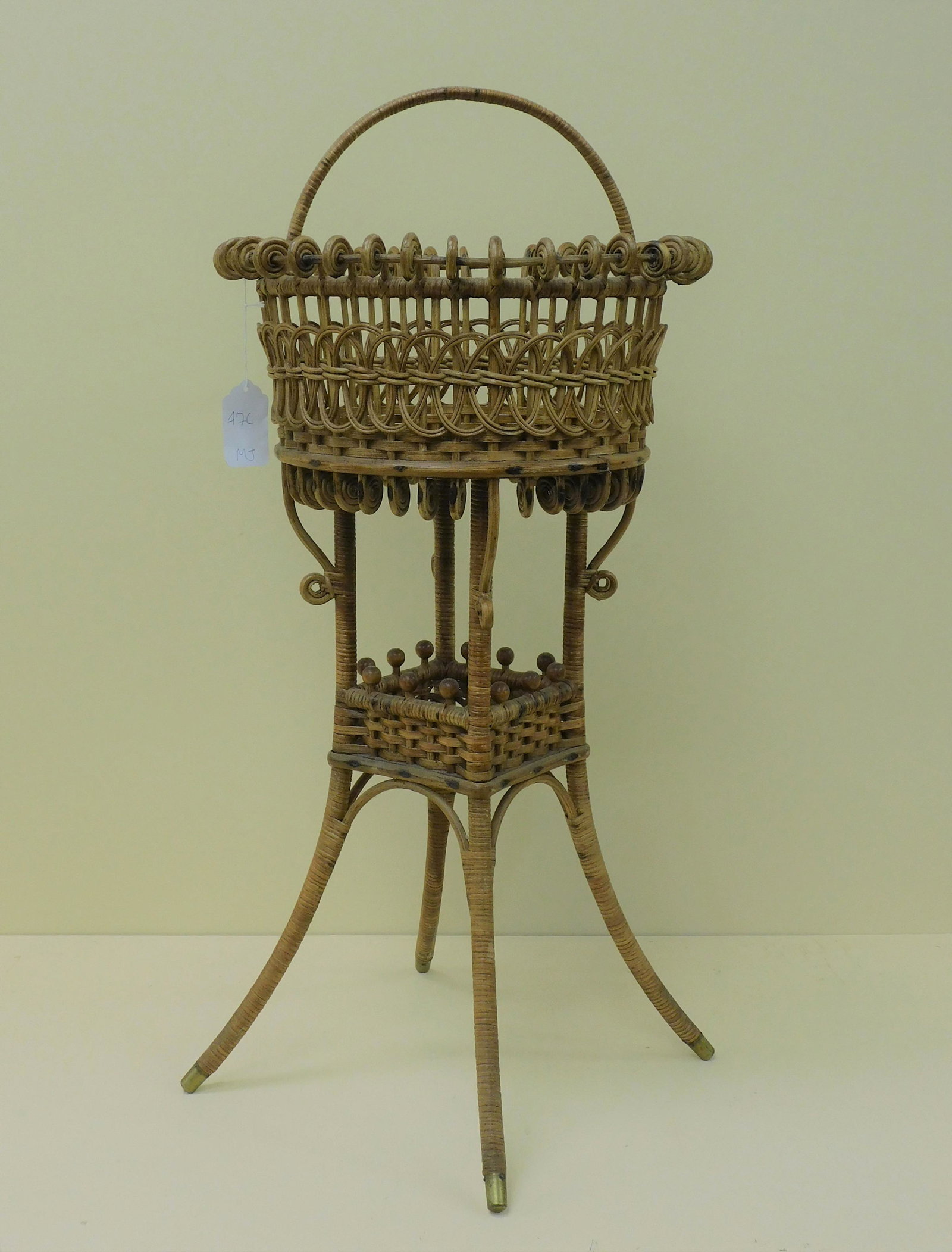 Swing handled wicker sewing basket, reed with: maple frame, ca. 1890. Original natural finish, unknown maker. Curlicue rim at top, interlocking spirals on sides. Bottom shelf with beaded gallery. 29" high, 16 1/2" diameter. Excellent original cond