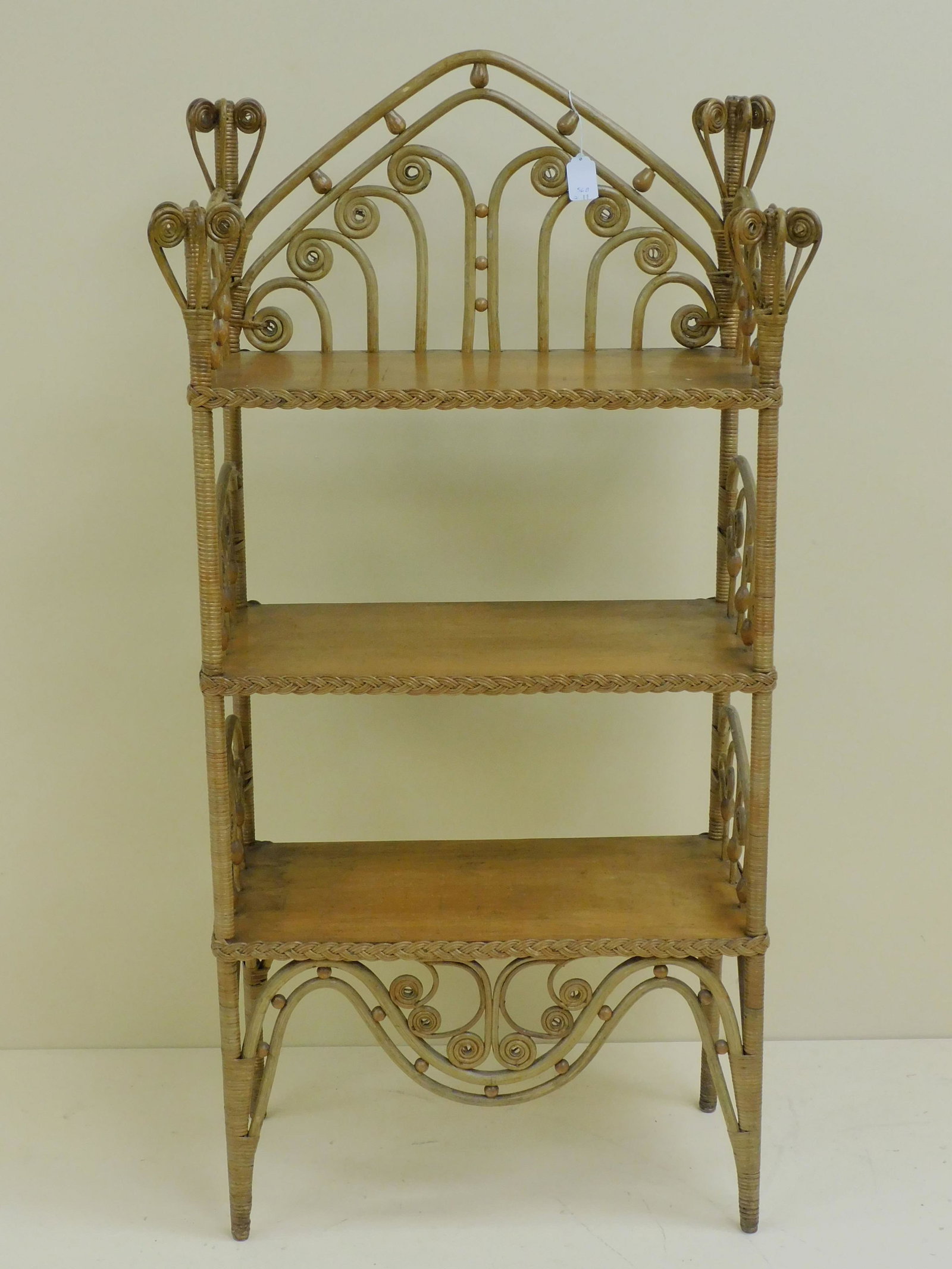 Victorian wicker whatnot stand, ca. 1895.: Curlicue finial, 3 oak shelves, oak frame, natural finish, probably original. 42" high, 22" wide, 10 1/2" deep. Good original condition. Provenance: Mary Jean McLaughlin Collection.