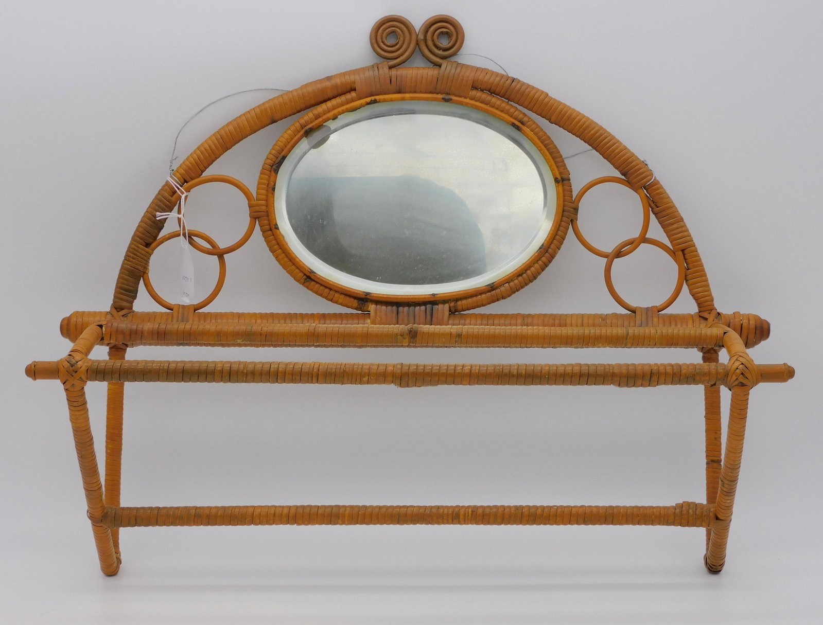 (2) Victorian wicker pieces, to include: an early: hanging towel rack with original beveled glass mirror, ca. 1880, possibly Wakefield Rattan Co., 16" high, 22" wide, 16 1/2" deep. Good original condition with some minor rewrapping. Along with a Victo