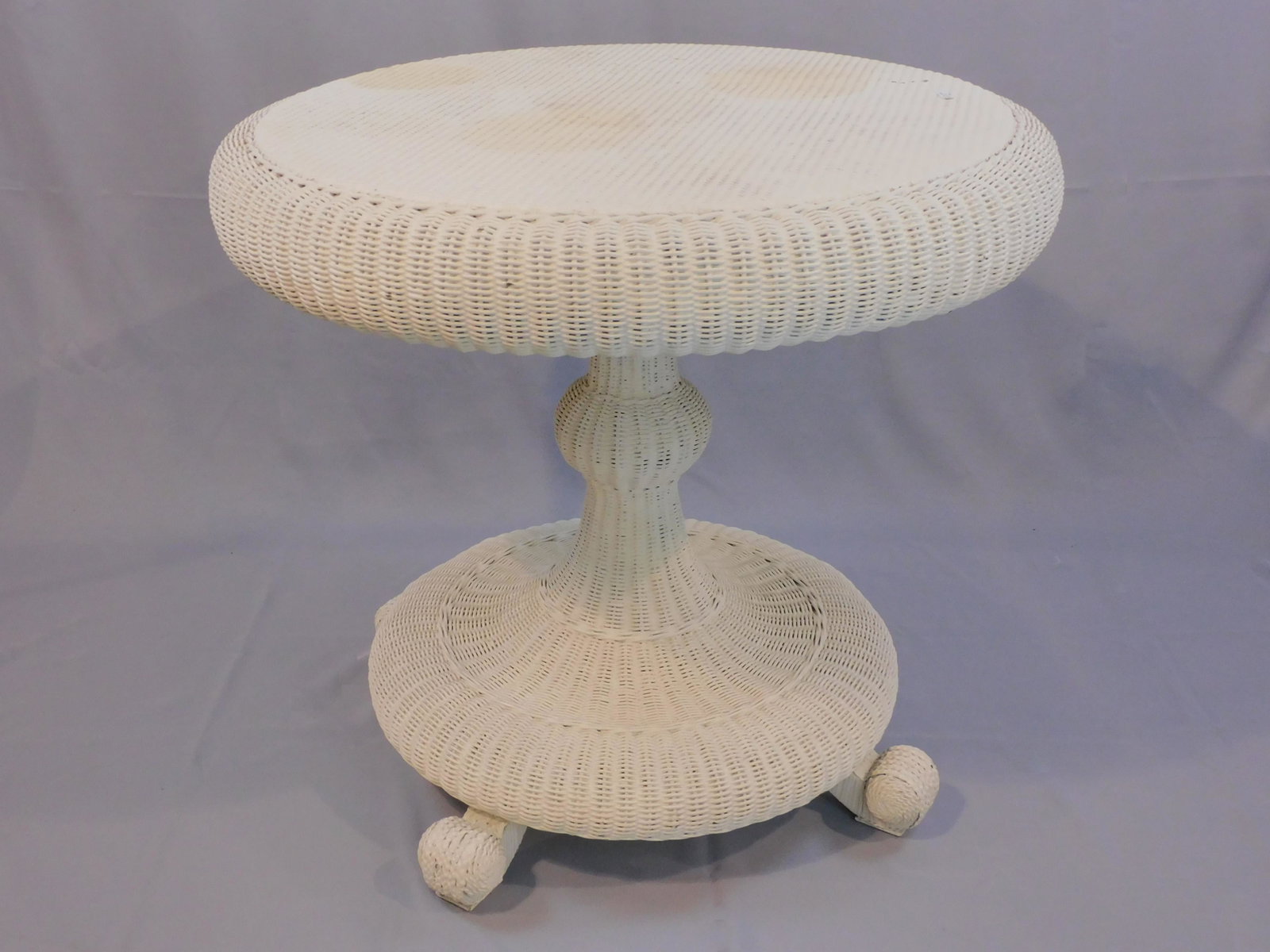 Victorian wicker tip-top parlor table, ca.: 1898-1899. Woven top, rolled edge. Pedestal base with empire style feet in old worn white paint. Retains original Heywood Brothers Wakefield Co. label on underside. Very good condition. 29" high, 33" 