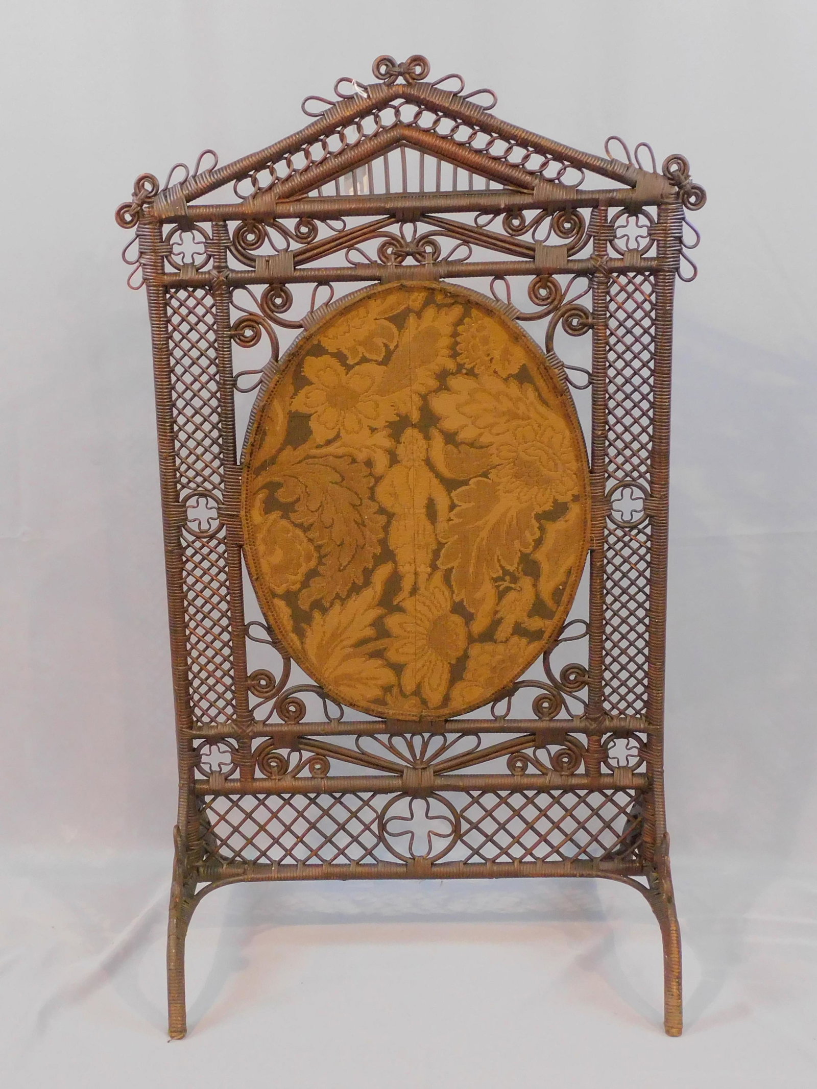 Victorian wicker fire screen, ca. 1880, possibly: Wakefield Rattan Co. Original natural finish. Oval inset tapestry woven fabric panel depicting a man dressed in 17th c. attire surrounded by flowers and two birds. Excellent original condition. 44" hi