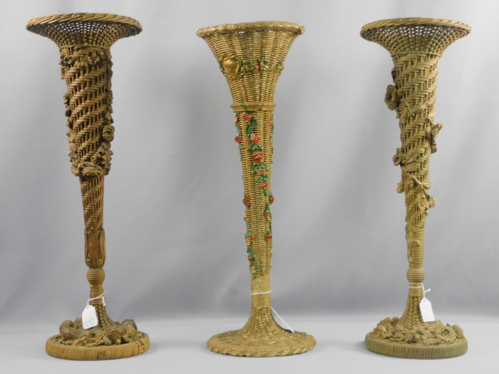(3) wicker trumpet-form vases with applied gesso: floral decoration. Old painted finish. 24" high, 8" diameter. Slight loss to gesso and minor paint loss. Provenance: Mary Jean McLaughlin Collection.
