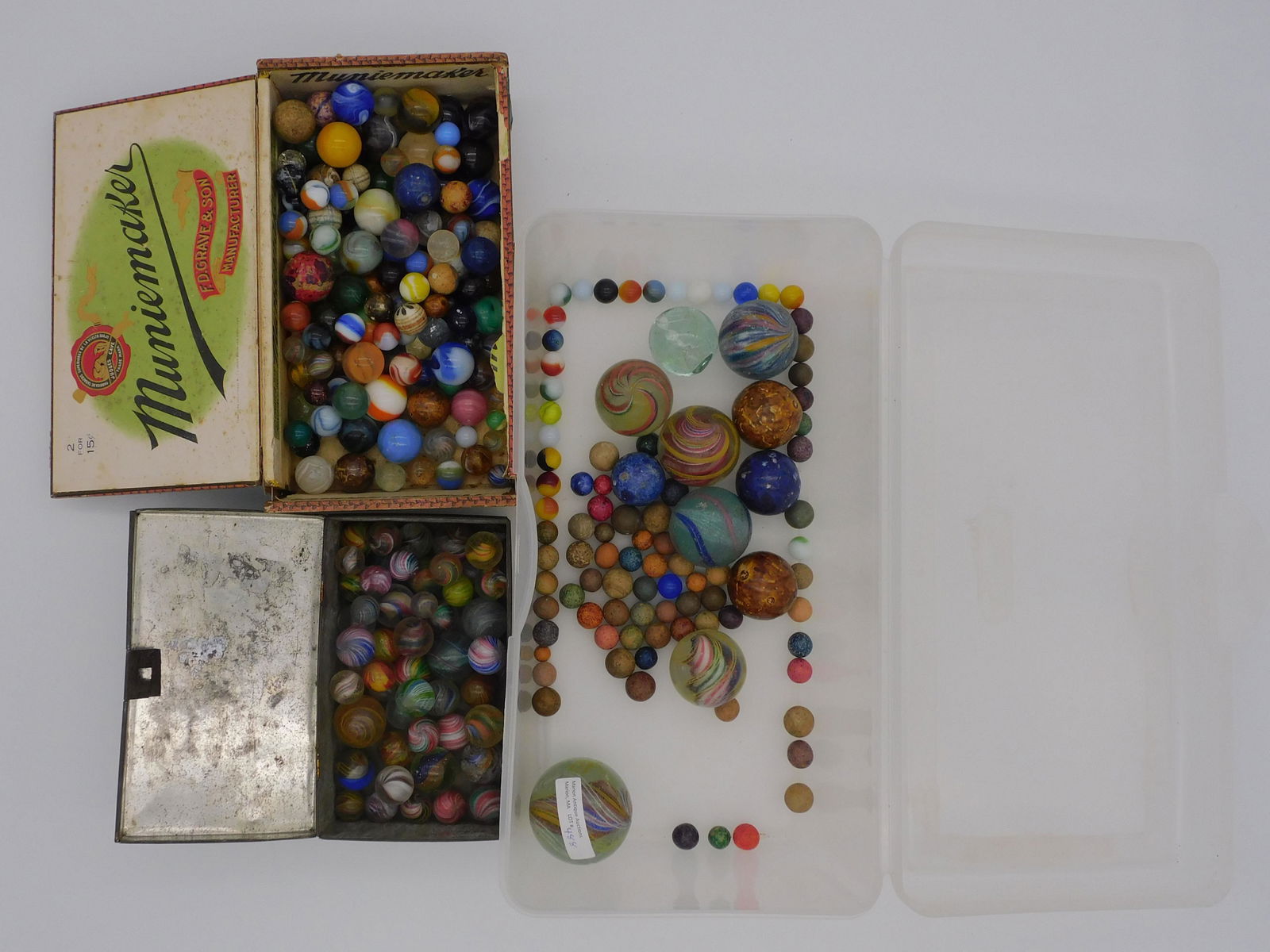 Large lot of 19th c. marbles. One very large: sulfide with swirl design, 2" diameter, some chipping. Five large sulfides with swirl design, about 1 1/2" diameter, all show wear and minor chipping. Four larger pottery marbles, two are Bennington o