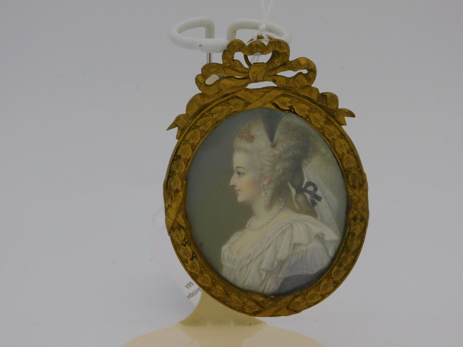 Miniature portrait depicting Marie Antoinette,: ca. late 18th c. Identified on verso, "Marie Antoinette", under which "C. B." is written. Depicts the queen in profile, wearing typical early 1790s garb and hairstyle. In an ornate brass frame, 4" x 2