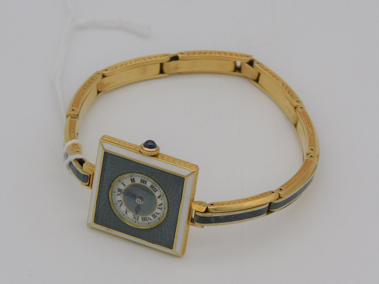 A fine gold and enamel bracelet watch. Early 20th: c. 18kt gold, 17 jewels, Swiss made. Comes with original Tiffany & Co. receipt, Jan 31, 1913. Matching gold and enamel bracelet band. Watch face is 7/8" square. Overall 22.5 dwt.