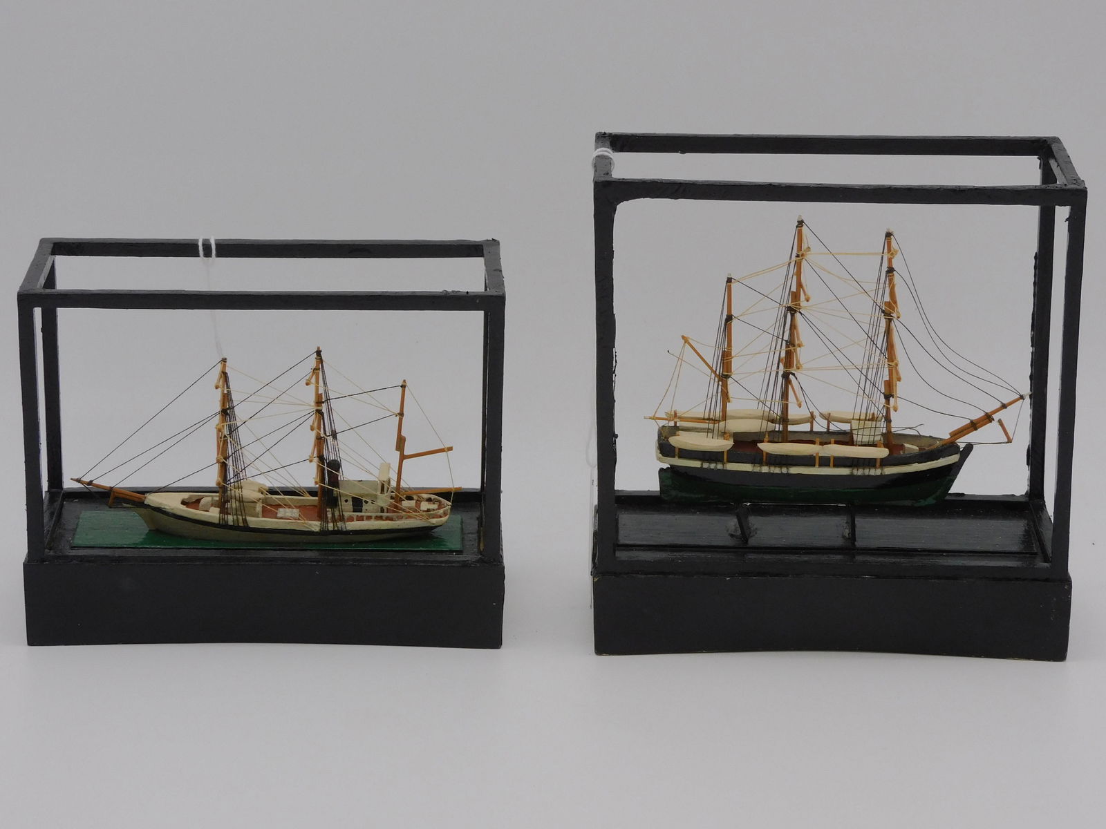 (2) miniature ship models by Hingham artisan: Eugene S. Harrington. One depicts the Charles W. Morgan, signed on bottom. Overall in case 6" high, 5 1/2" wide, 2 1/2" deep. The other depicts a steam powered bark, overall in case 4 1/2" high, 5 1/2