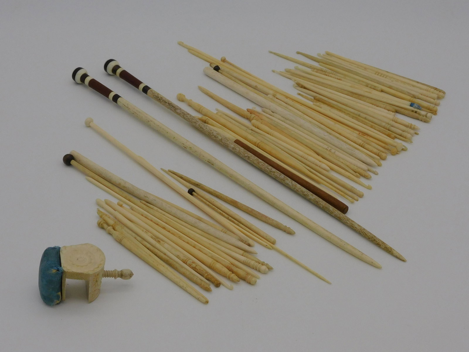 Large scrimshaw sewing lot, 19th c. To include:: pair of knitting needles, whalebone, baleen, and mahogany, 13 1/2" long. A carved bone pin cushion, probably Chinese export, approx. 2 1/2" x 1 1/4". A lot of 64 crochet and knitting needles, ranging 