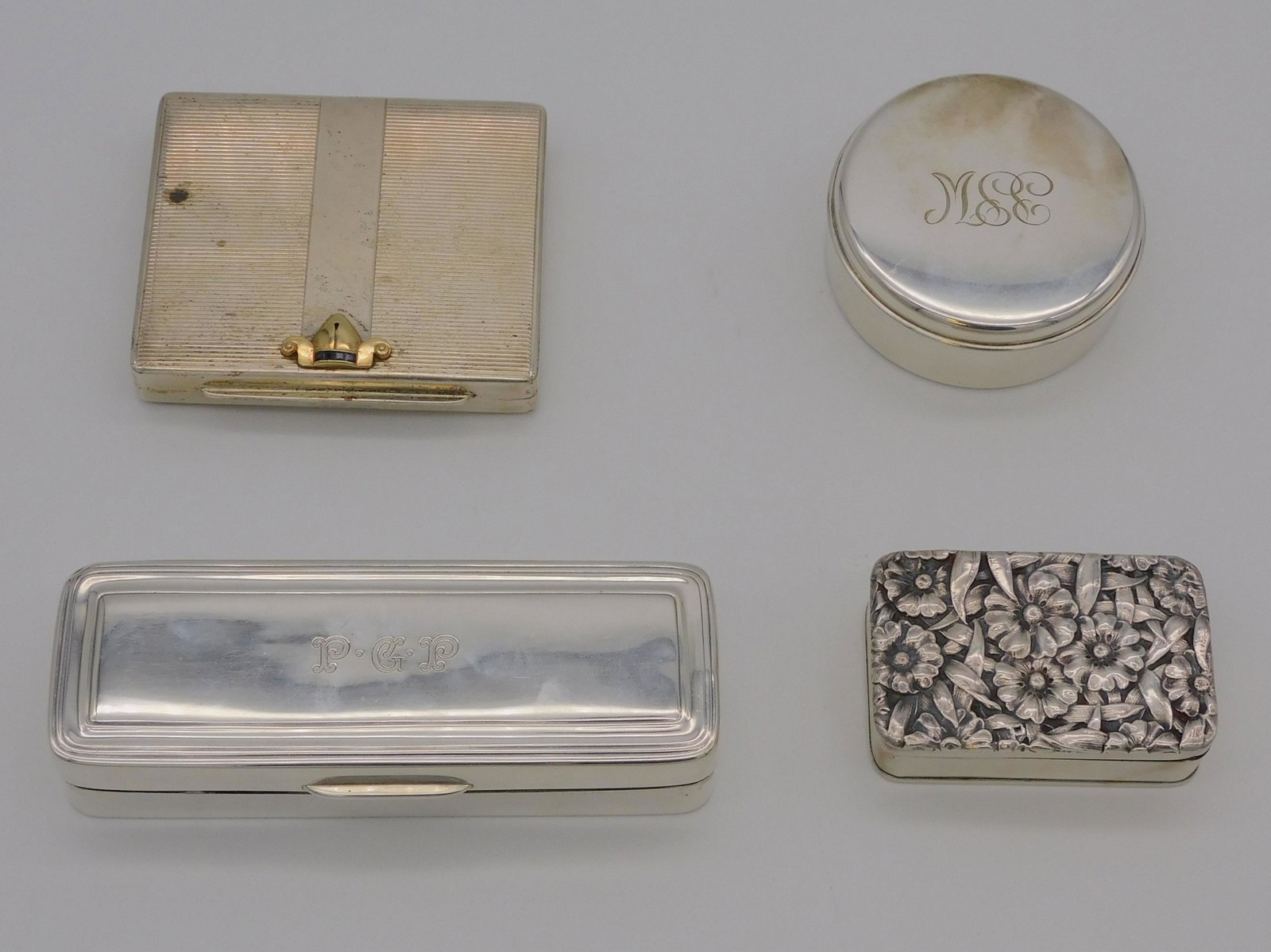 (4) Sterling Silver boxes, 20th century. To: include: Tiffany silver rectangular box and monogram, 1" high, 5 1/4" wide. A round Tiffany silver box with monogram, 1 1/8" x 2 3/4" dia. A repousse hinged lid box with dedication, "Miss Peggy from P