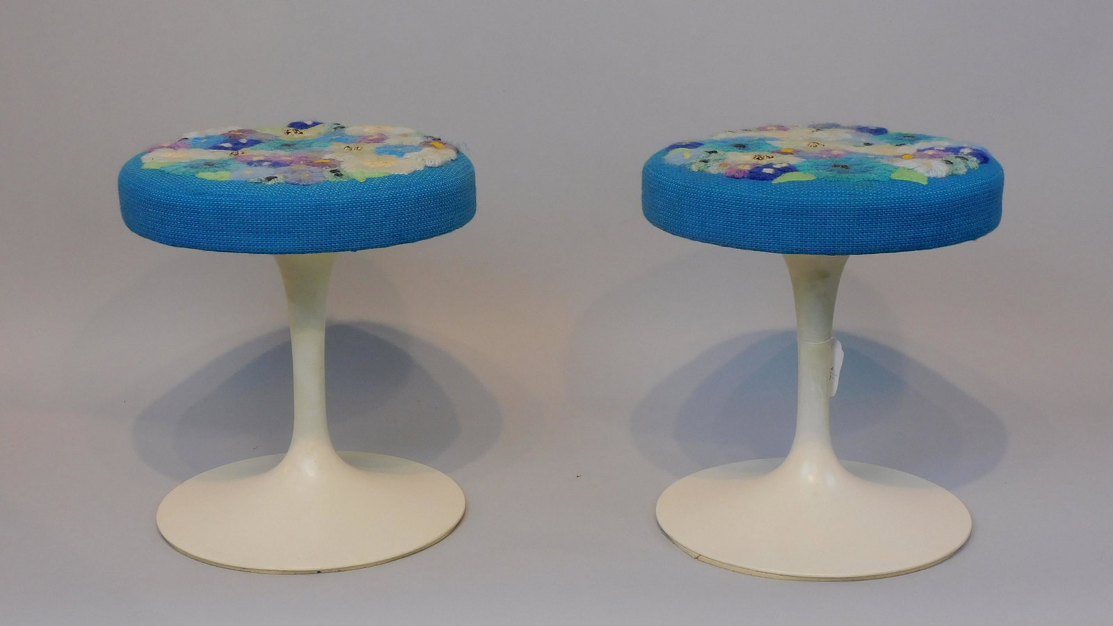 Eero Saarinen (1910-1961, Finland, America) for: Knoll, pair of tulip stools with original labels, ca. 1960s. Unique needlepoint upholstery. Good condition. 16" high, 14 1/2" diameter.