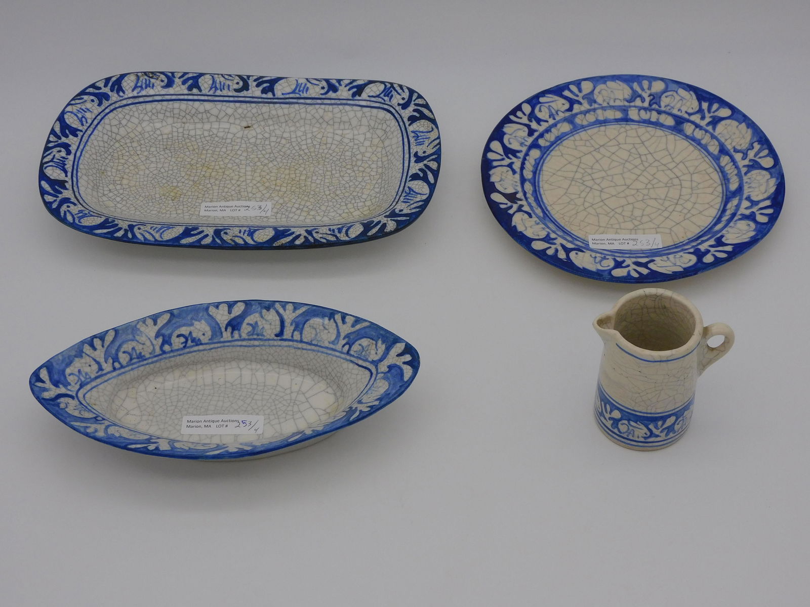 (4) pieces of early Dedham pottery, rabbit: borders. To include: 3" high creamer. A plate, 3/4" high, 7 1/2" diameter. Rectangular tray, 1 1/2" high, 10" x 6 1/4". An elliptical tray, 1 1/2" high, 8 1/4" x 4 1/4".