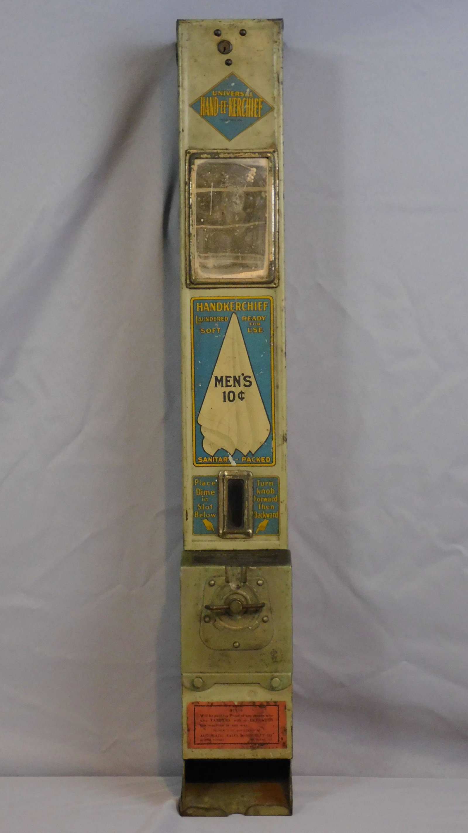 Hand-EE-Kerchief, ca. 1928. Coin operated vending: machine. Made by Universal Handkerchief Mfg. Co. Retains original decals and mirror. Age appropriate wearing, some light foxing. 33 1/2" high.