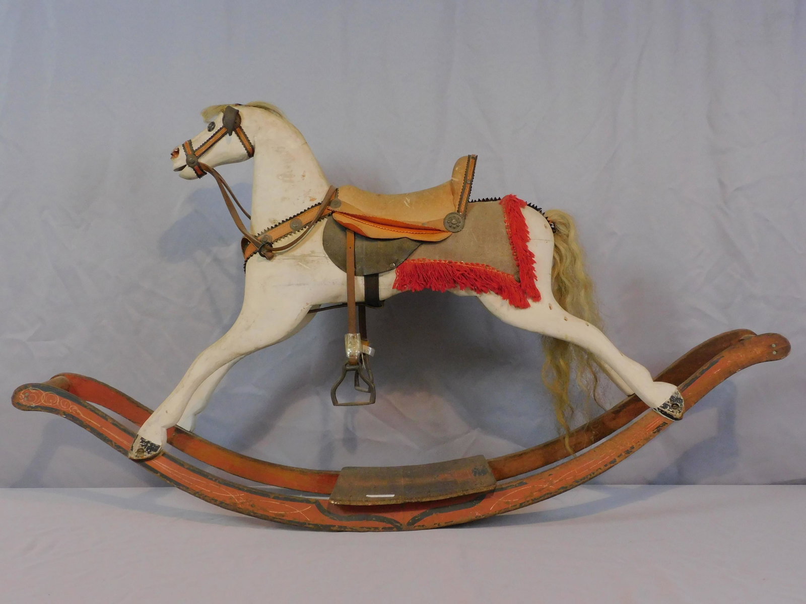Carved and painted rocking horse, 19th c. Wood.: Leather saddle, yarn trim, horsehair tail, leather reigns, iron stirrups. Very good overall condition consistent with age and light use. 28 1/2" high, 49" wide, 10 1/2" deep.