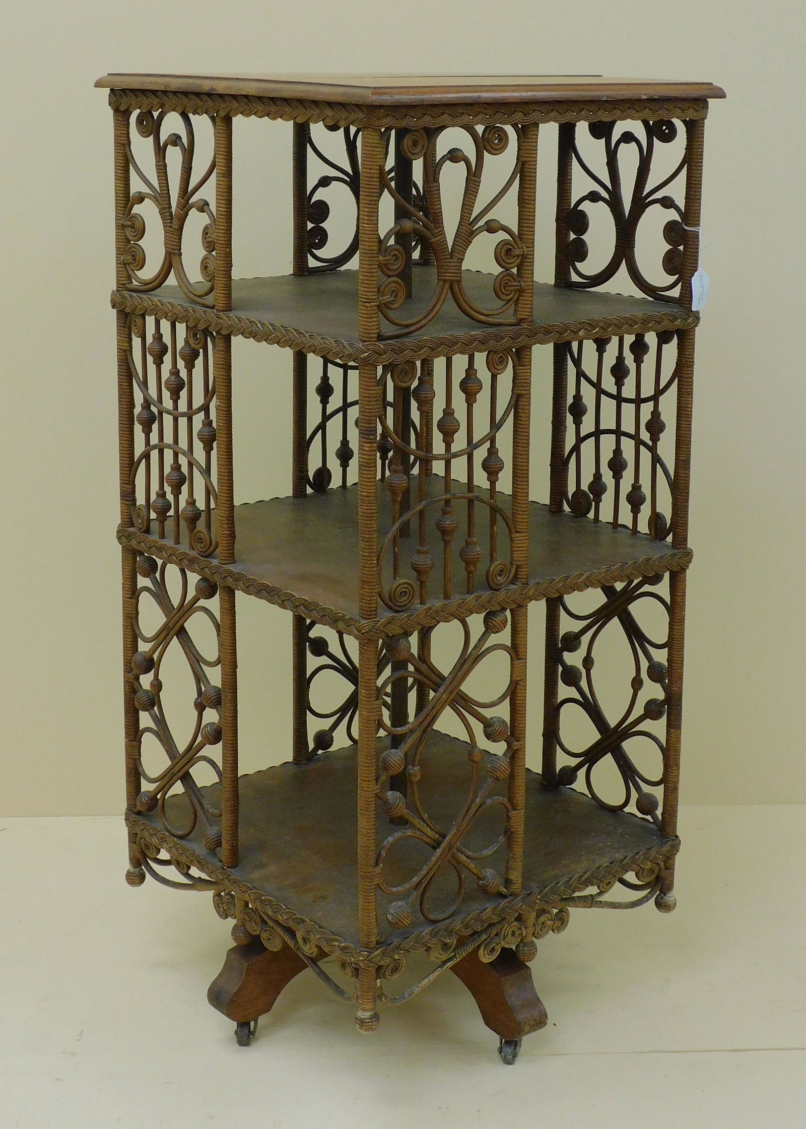 Rare Victorian wicker revolving bookcase.: Quartersawn oak shelves, curlicue, stick and ball design. Oak swivel base. Original natural finish. 40" high, 18 1/2" x 18 1/2". Top shows seam separation, shelving shows light staining. Slightly wobb
