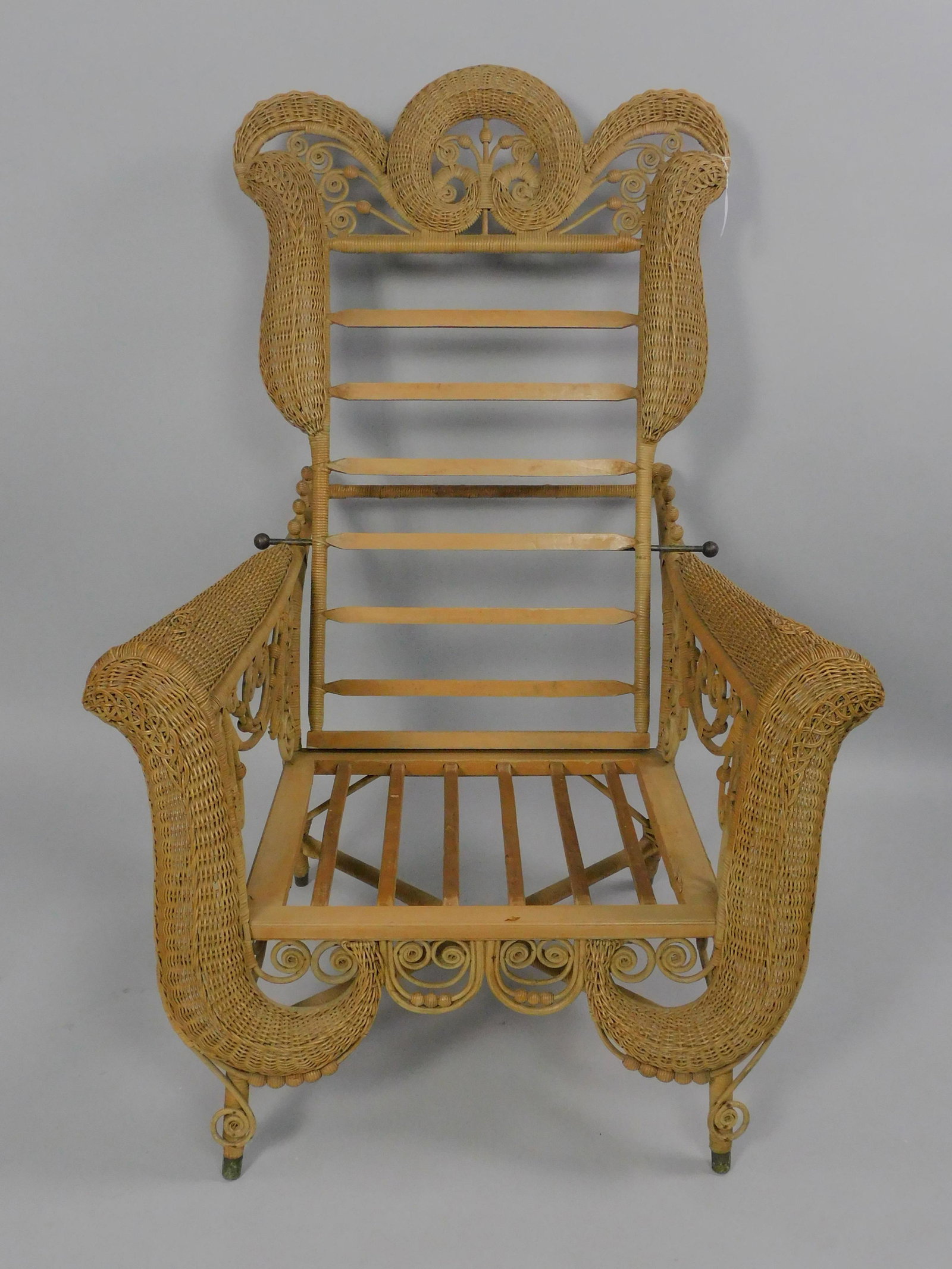 Extremely rare Victorian wicker Morris chair, ca.: 1898, #6523 in the Heywood Bros and Wakefield Co. 1898 catalogue. Remnants of the old label on the underside. With the original cushions as pictured in the catalogue. Scrolled back with curlicue desig