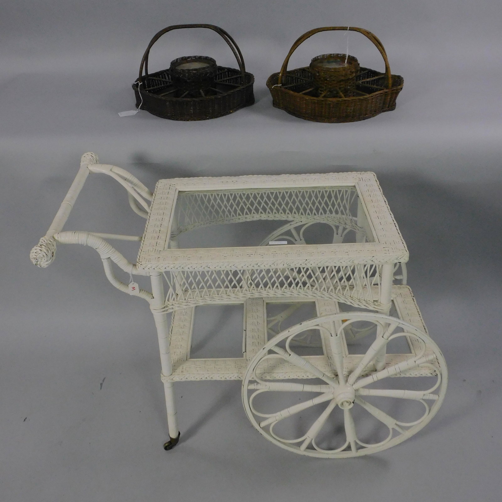(2) Wicker drink serving trays, ca. 1915.: Handled, with covered insert for ice. New metal liner. Slots for glasses, napkins, etc. 11 1/2" high, 18" wide, 16" deep. Original natural finish, shows minor loss to cane, one has a slightly lighter 