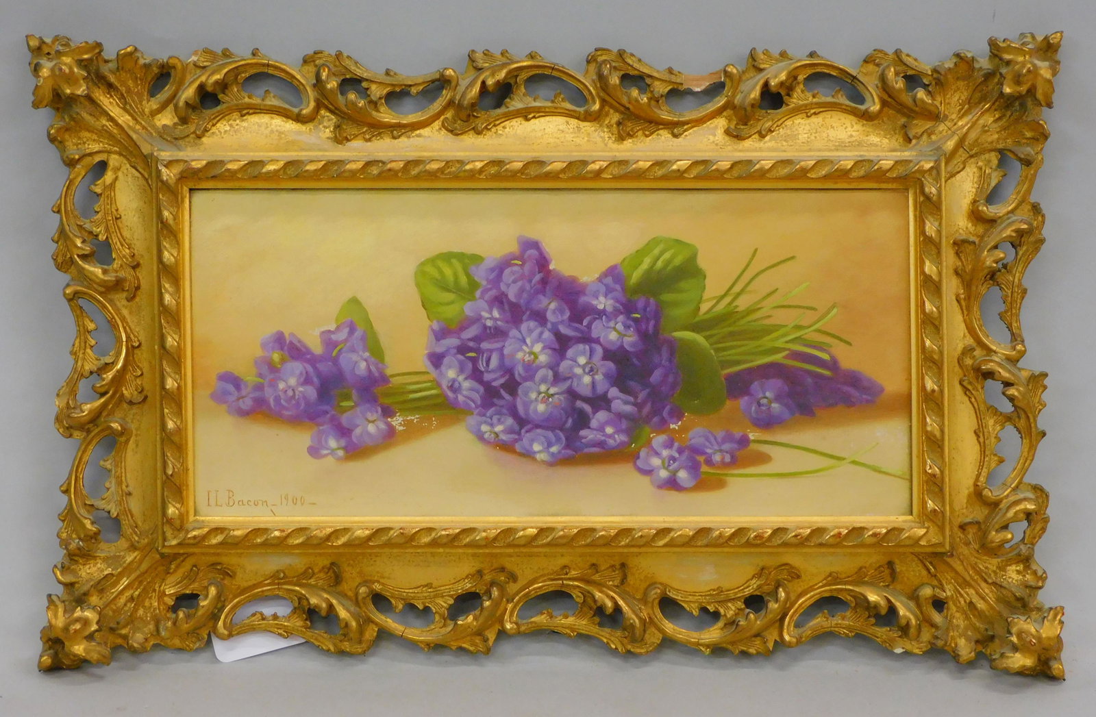 Irving Lewis Bacon (1853-1910, US) oil painting: on canvas, still life with flowers in an elaborate carved and gilded frame. Sight size 6" x 12 3/4", overall with frame 12" x 18". Frame shows minor losses. Painting has several small areas of paint l