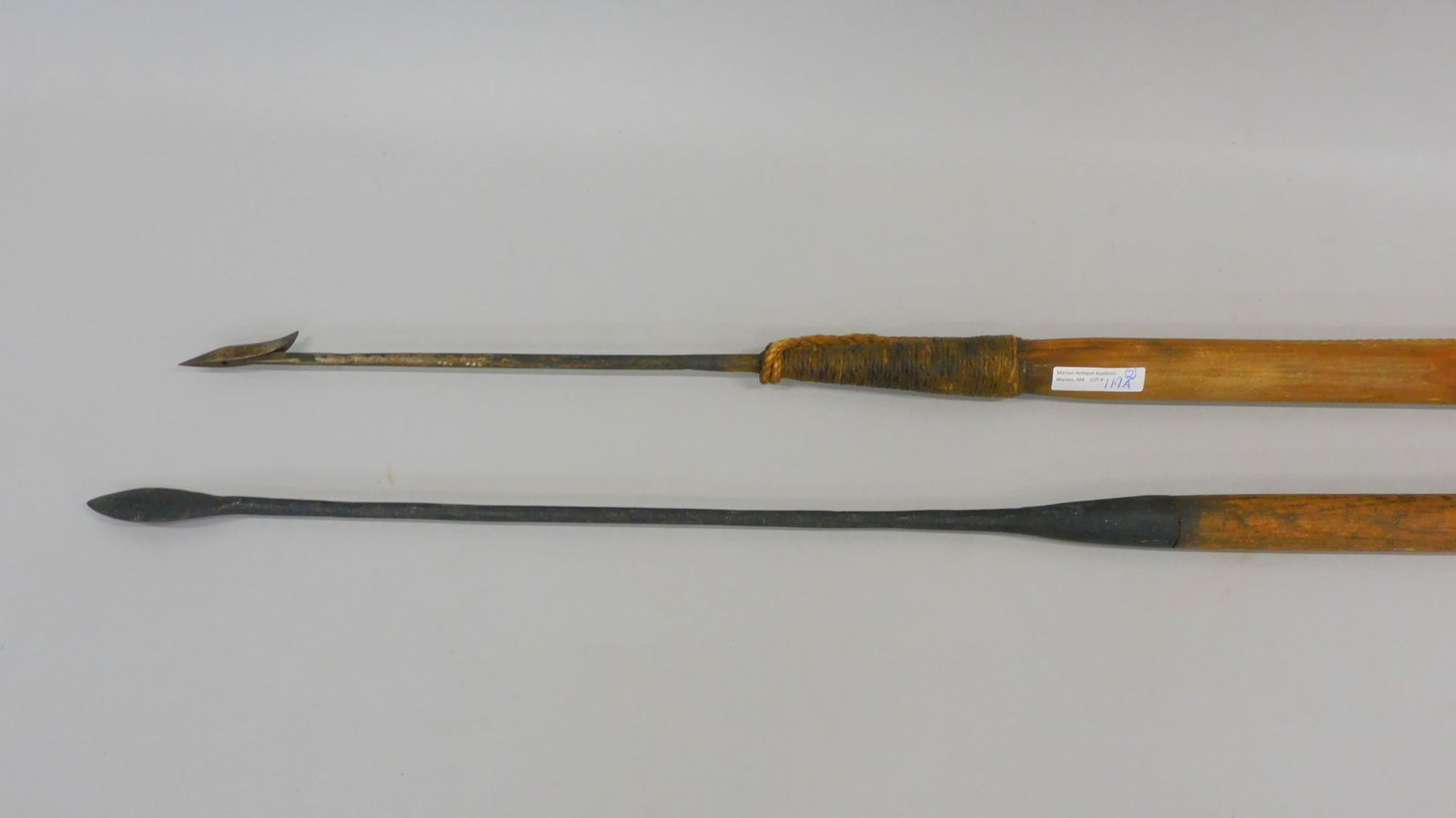 Diminutive harpoon and lance. Late 19th early: 20th century. (2) Whaling tools to include a toggle iron harpoon, signed illegibly, a short metal top and a long wooden shaft and old rope work 9' overall. Good condition. Lance has a short metal top