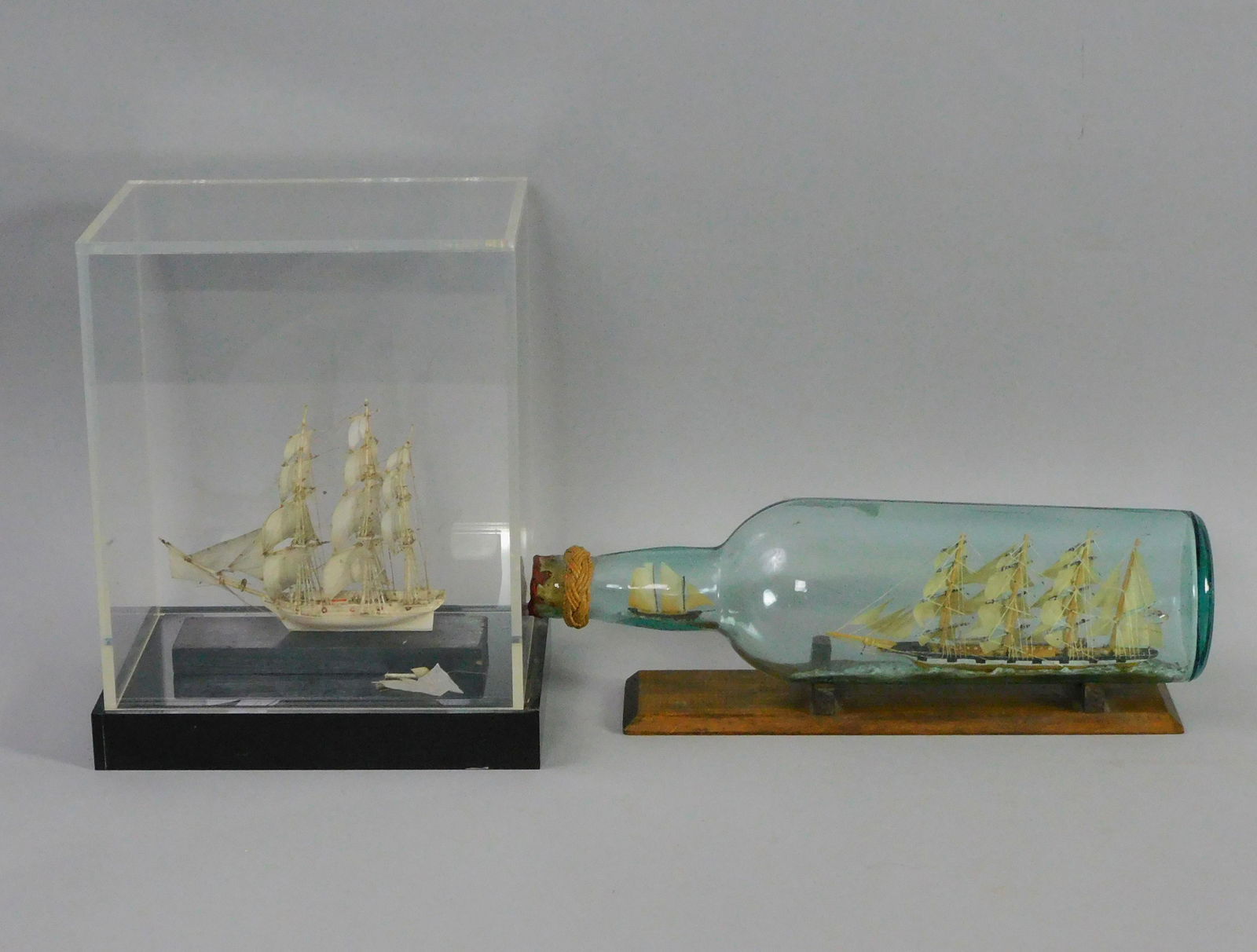 (2) miniature ship models. One whalebone in: acrylic case, fully rigged, shows damage. Approx 4" x 5", model size. 9" x 5 1/2". Comes with ship model with unusual smaller ship in bottle. 11 1/2" long.