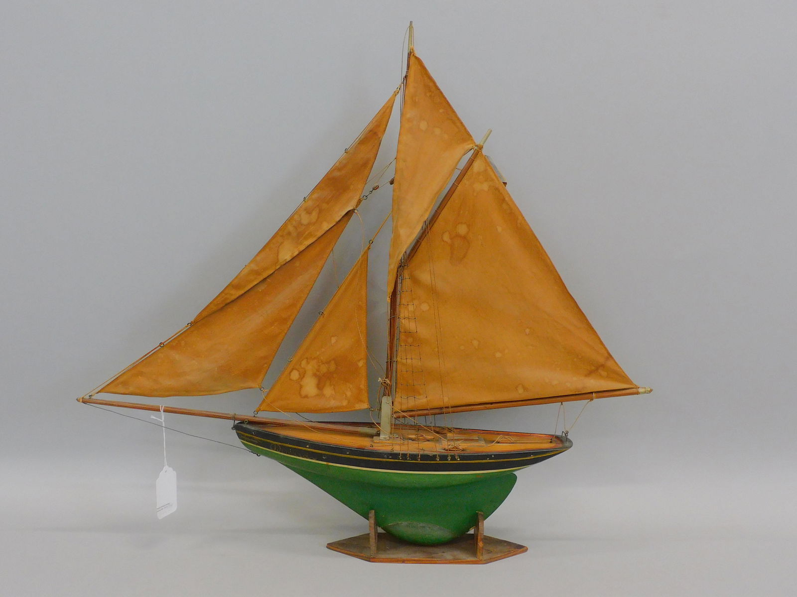 French pond model. Early 1900s.: Handmade wooden ship model with original sails and rigging and a lead keel. Original green and black painted hull with line-defined deck. Decorated painted waterline. It has an anchor on the boat's bo