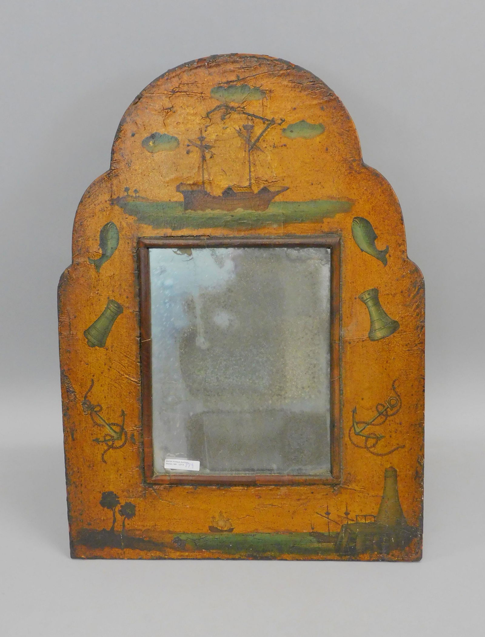 Carved and painted wooden tabletop mirror. 19th: c. Gilt and painted leather over wood with nautical motifs, depicting ships, lighthouse, anchors, fish, cannon, and a rook. Old glass in as found condition. Made in England. Back has hinged support. 2