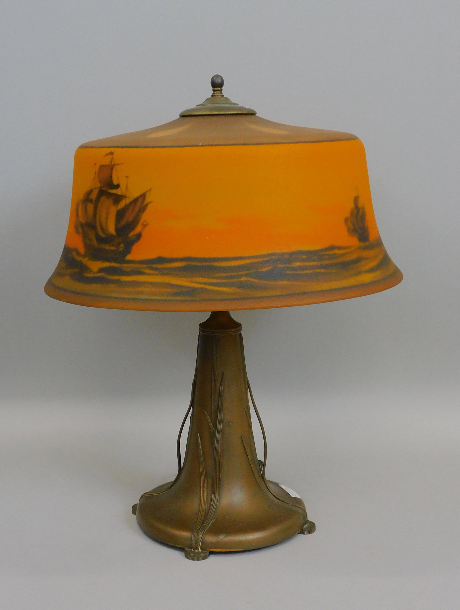 Pairpoint lamp, circa 1915. Reverse hand painted: shade depicting the ships Nina, Pinta, and Santa Maria. Signed on inner shade rim Pairpoint Company. Signed on base. 19" high, approx 16" diameter.