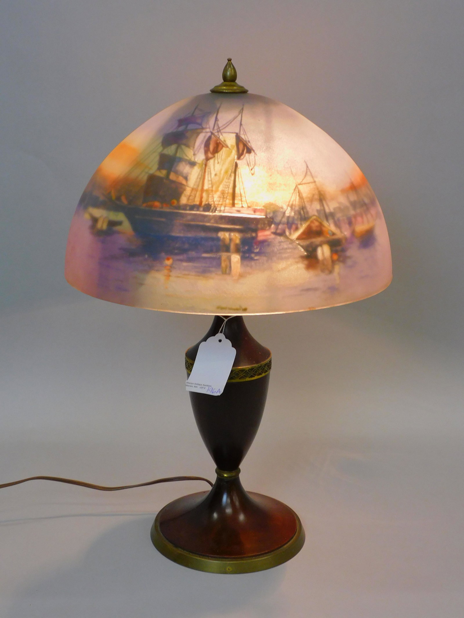 Reverse painted Pairpoint lamp. Early 20th: century. Harbor scene with whale ships possibly New Bedford, MA. The glass shade is signed Pairpoint Corporation on the inside. It has the original wooden Pairpoint base. The shade is 13" in diameter 
