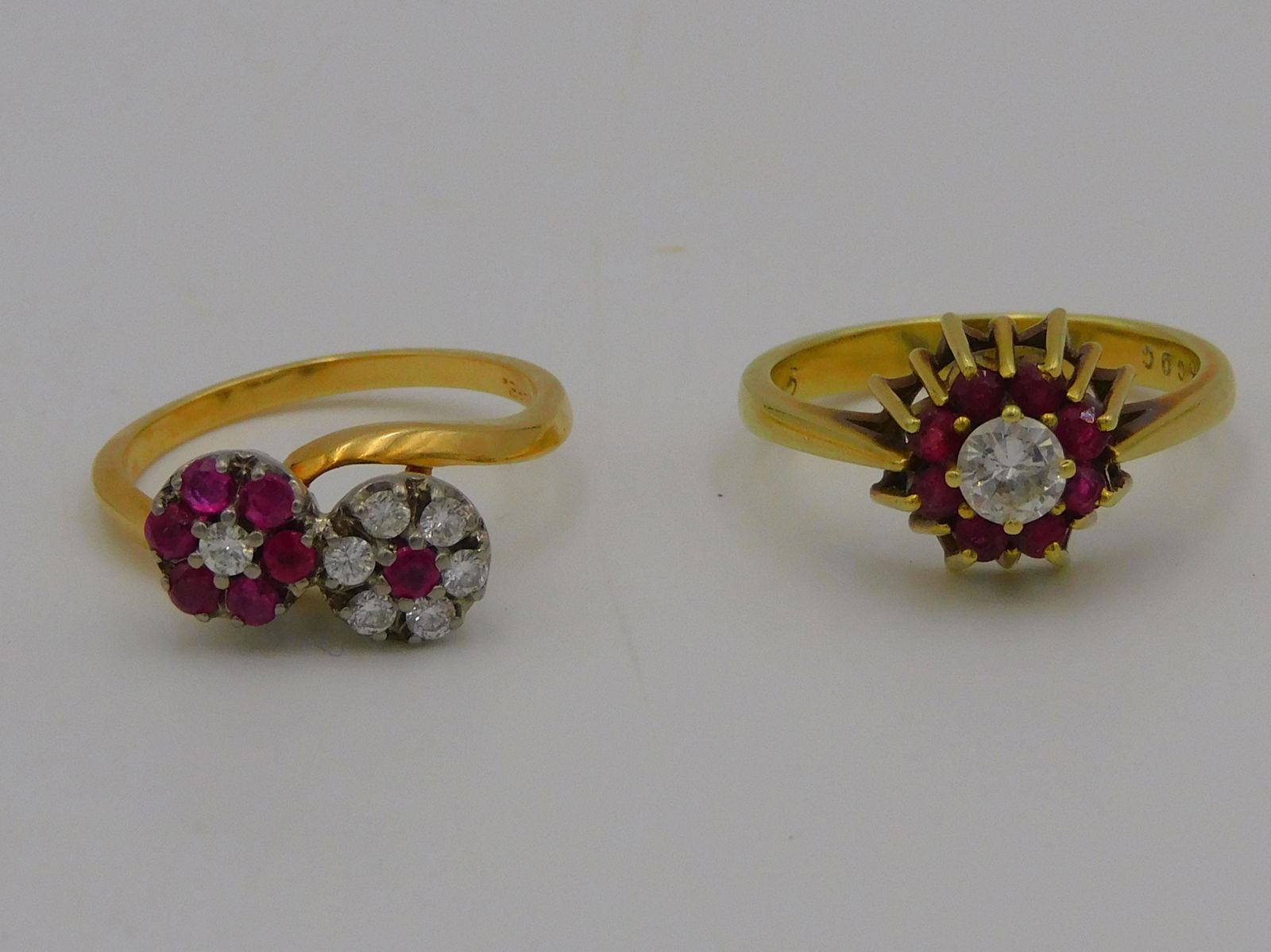 (2) 14kt. yellow gold rings, both set with: diamonds and rubies, approx. size 6 1/2 and 6. To include: a double cluster ring set with seven 2mm rubies and seven . 03 carat each full cut diamonds. As well as a ring set with an approximately . 5