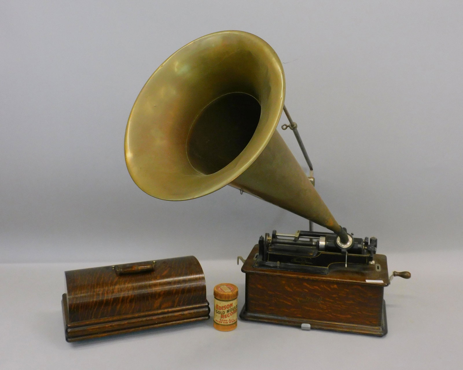 Edison cylinder phonograph. Brass horn. One: cylinder. Old natural finished oak case. Working but needs adjustment. Approx 32" high x 16" wide and 37 1/2" deep with horn.