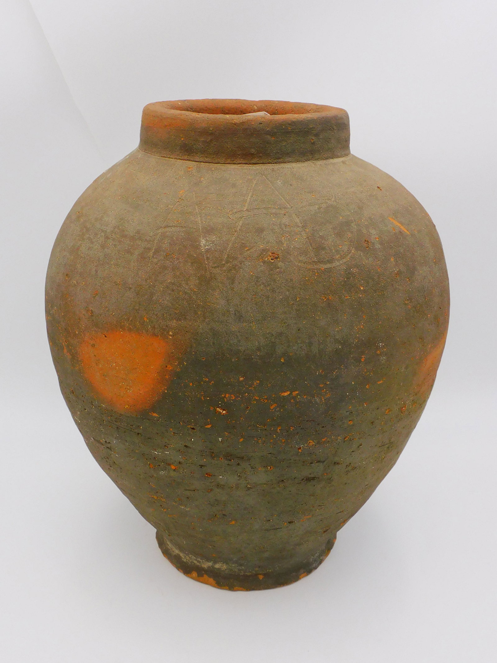 Wampanoag redware water jar. 18th/19th century. A: redware clay water jar made by the Gay Head Wampanoag culture of Martha's Vineyard. The jar has an incised stylized initials. 15 1/2" x 12" dia x 5" opening. Overall excellent condition. Similar to a